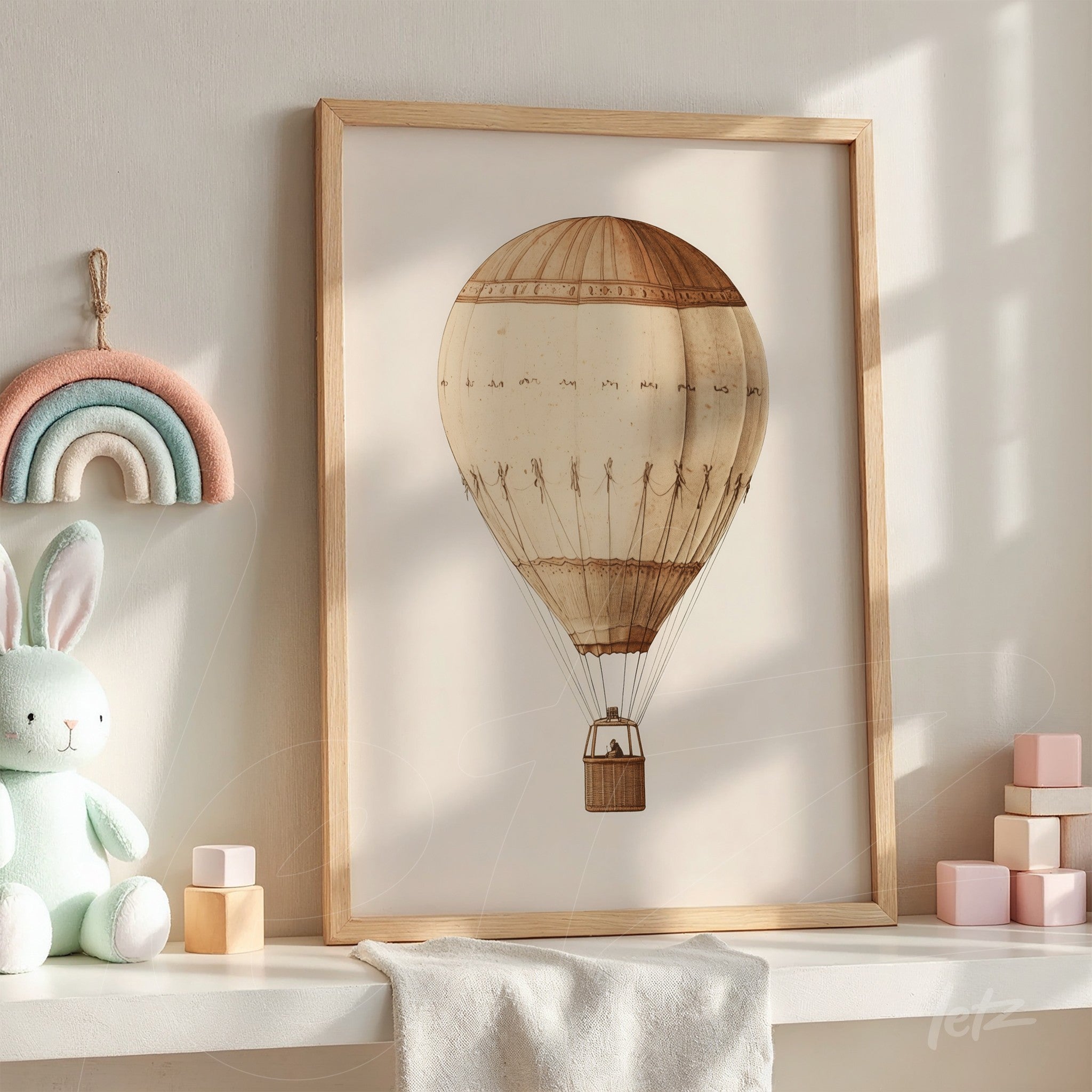 quadro com ilustração de um balão de ar quente vintage em moldura de madeira clara, exposto em ambiente iluminado com brinquedos coloridos ao redor