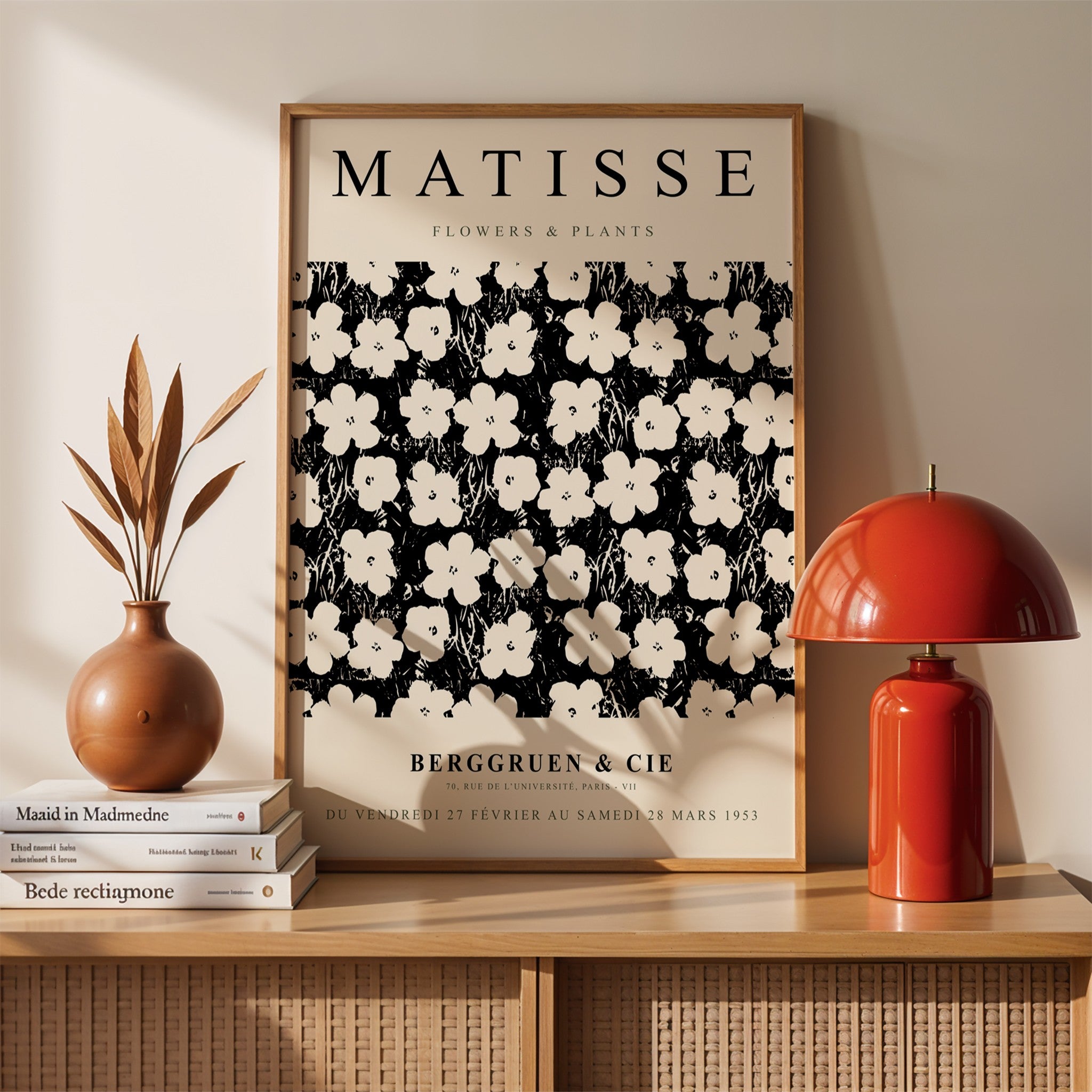 quadro emoldurado com arte de flores e plantas em preto e branco no estilo de Matisse, exibido em uma parede clara com elementos decorativos ao redor