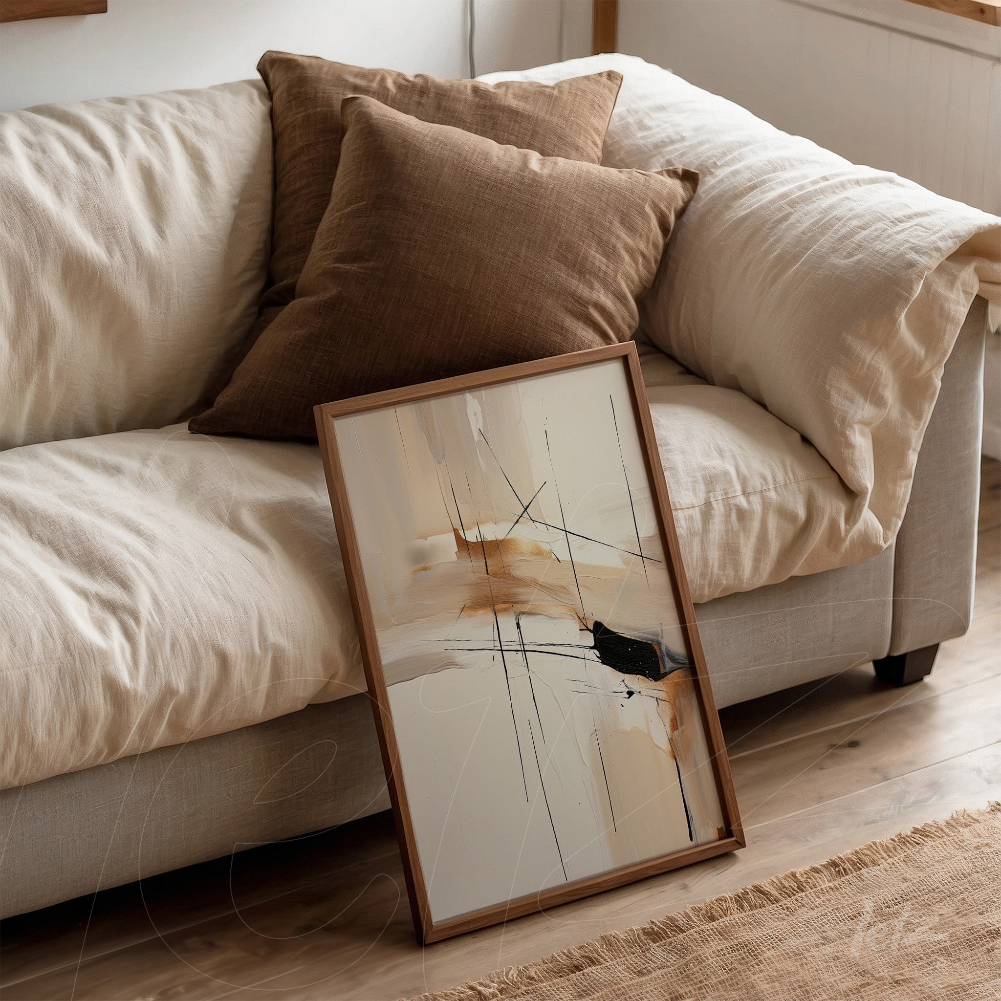 quadro com arte abstrata em tons terrosos e traços pretos, apoiado ao lado de almofadas em sofá claro