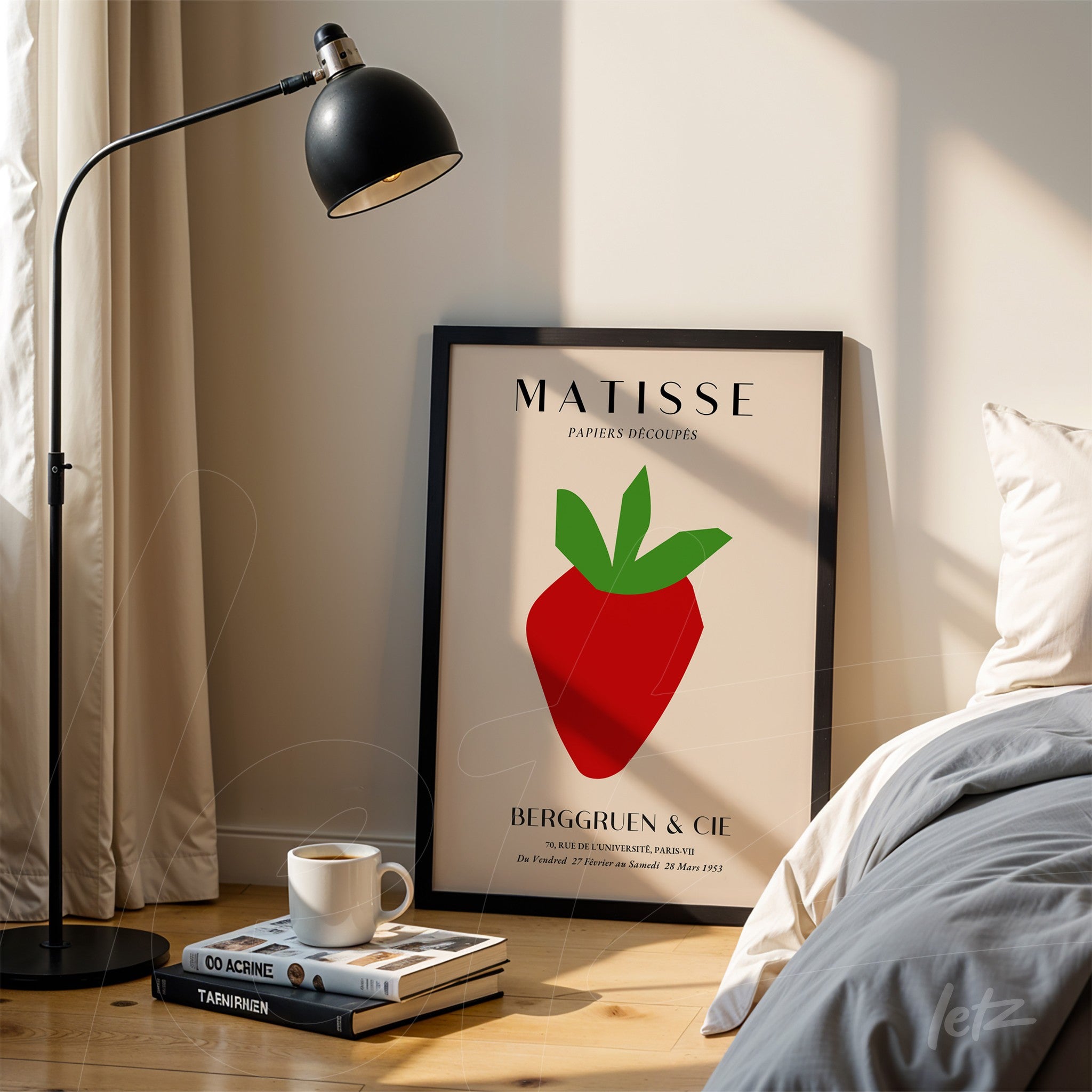 quadro decorativo em moldura preta exibindo uma ilustração de um morango estilizado com fundo claro, apoiado ao lado de uma luminária sobre um piso de madeira