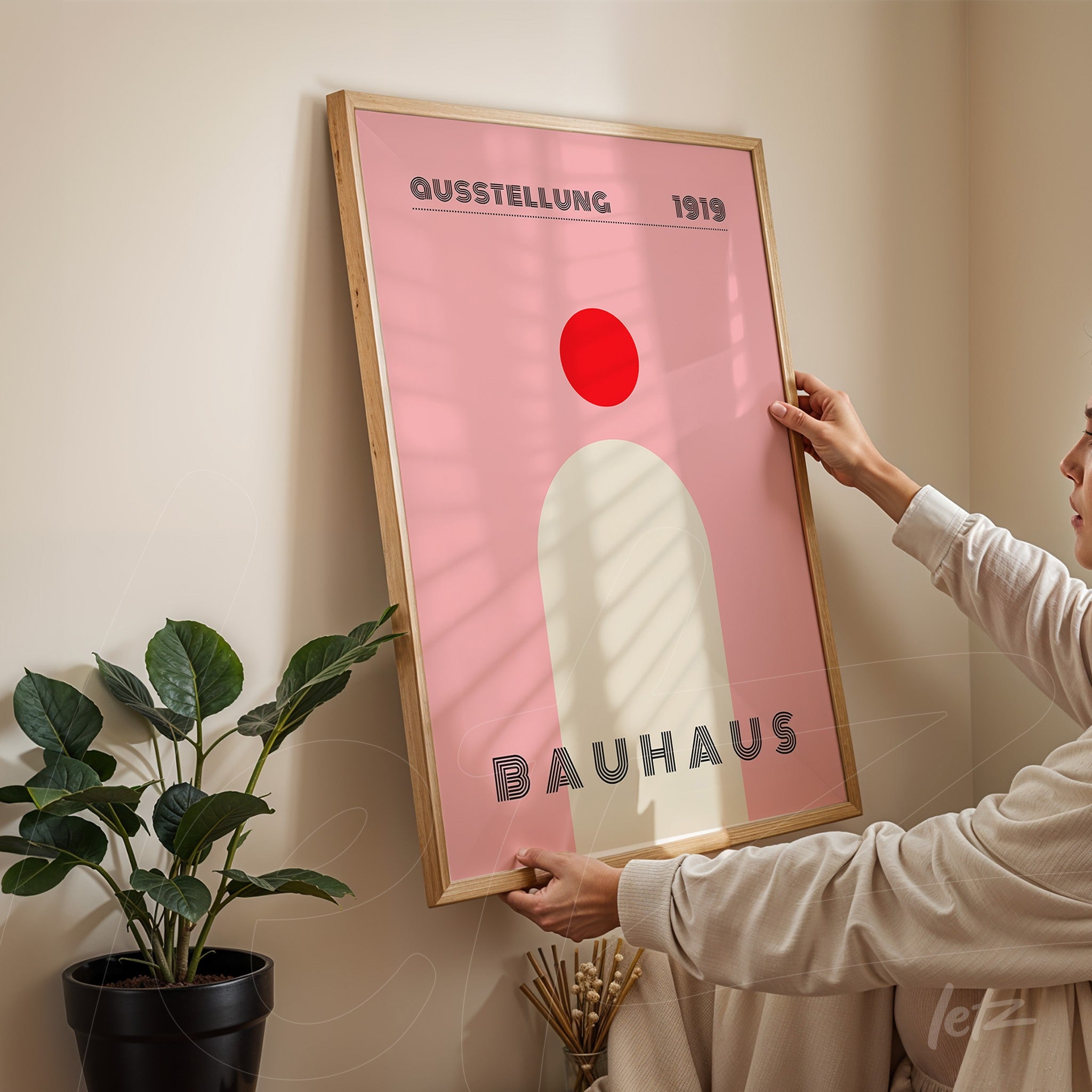 quadro com arte minimalista de bauhaus em tons de rosa e vermelho com moldura de madeira clara