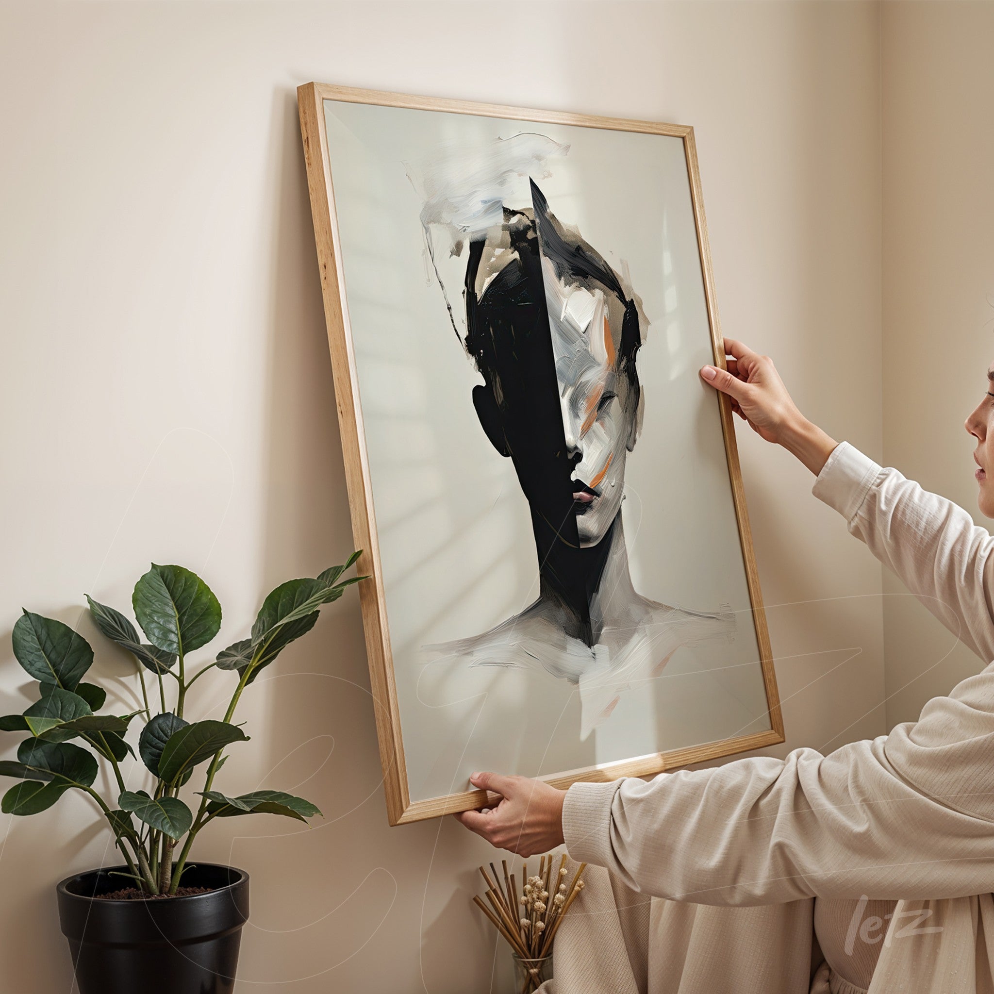 quadro em moldura de madeira claro com retrato abstrato em preto e branco de mulher segurado na vertical