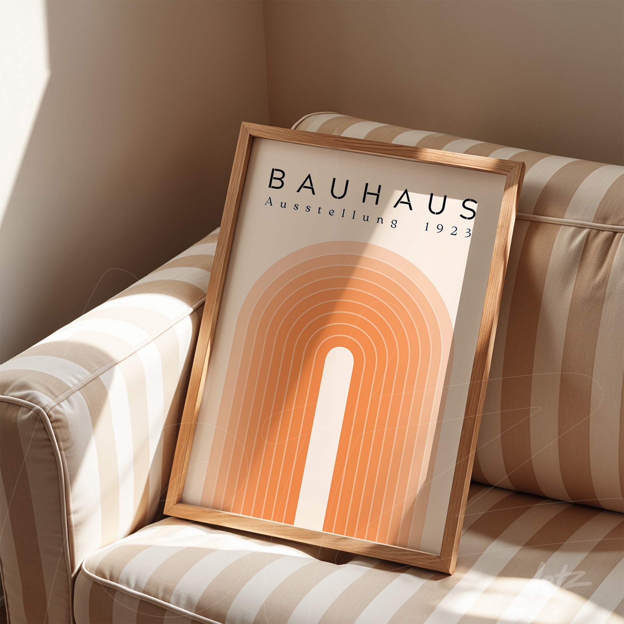 quadro estilo bauhaus com design geométrico em moldura de madeira clara sobre sofá listrado