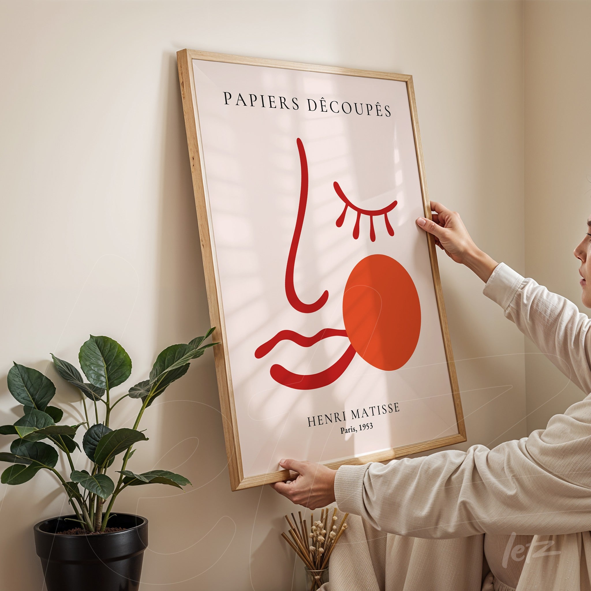 quadro com arte de Henri Matisse intitulado Papiers Découpés exibido em moldura de madeira clara em ambiente iluminado