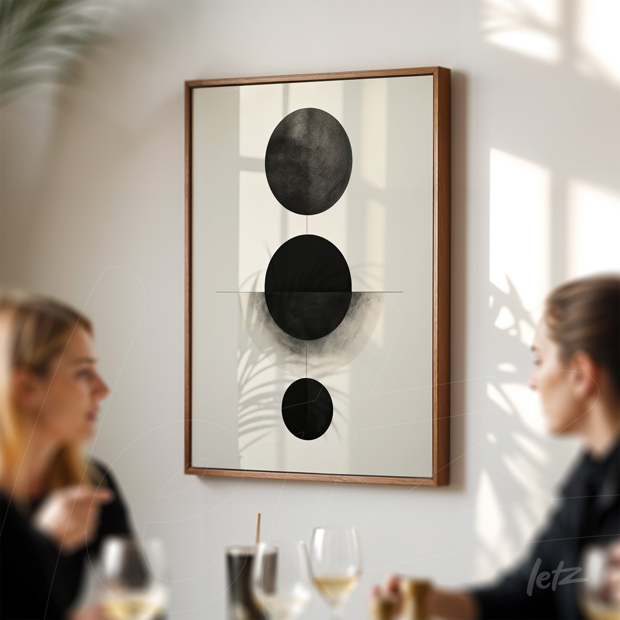 quadro com arte abstrata em tons de preto em moldura de madeira clara, exibido em parede com iluminação suave