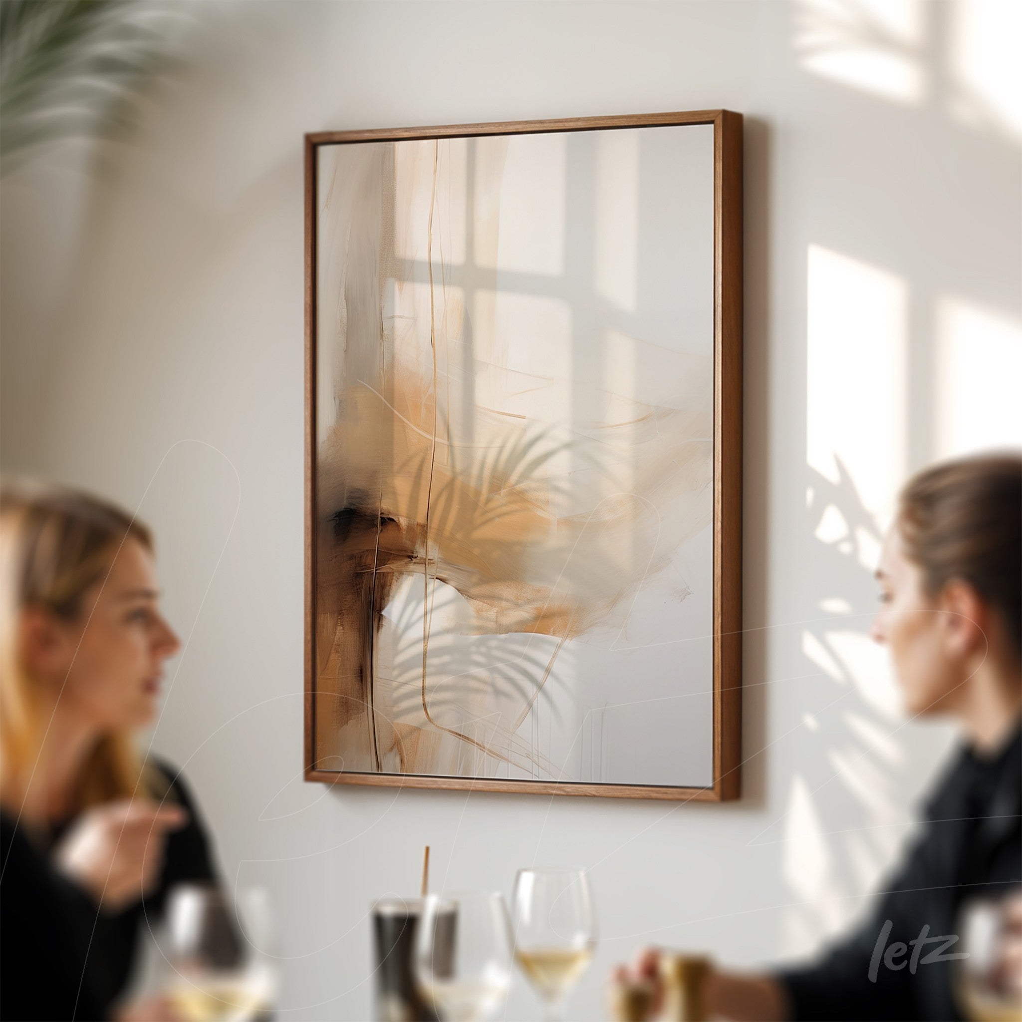 quadro abstrato com tons quentes e elementos de folhagem em moldura de madeira clara, exposto em parede branca