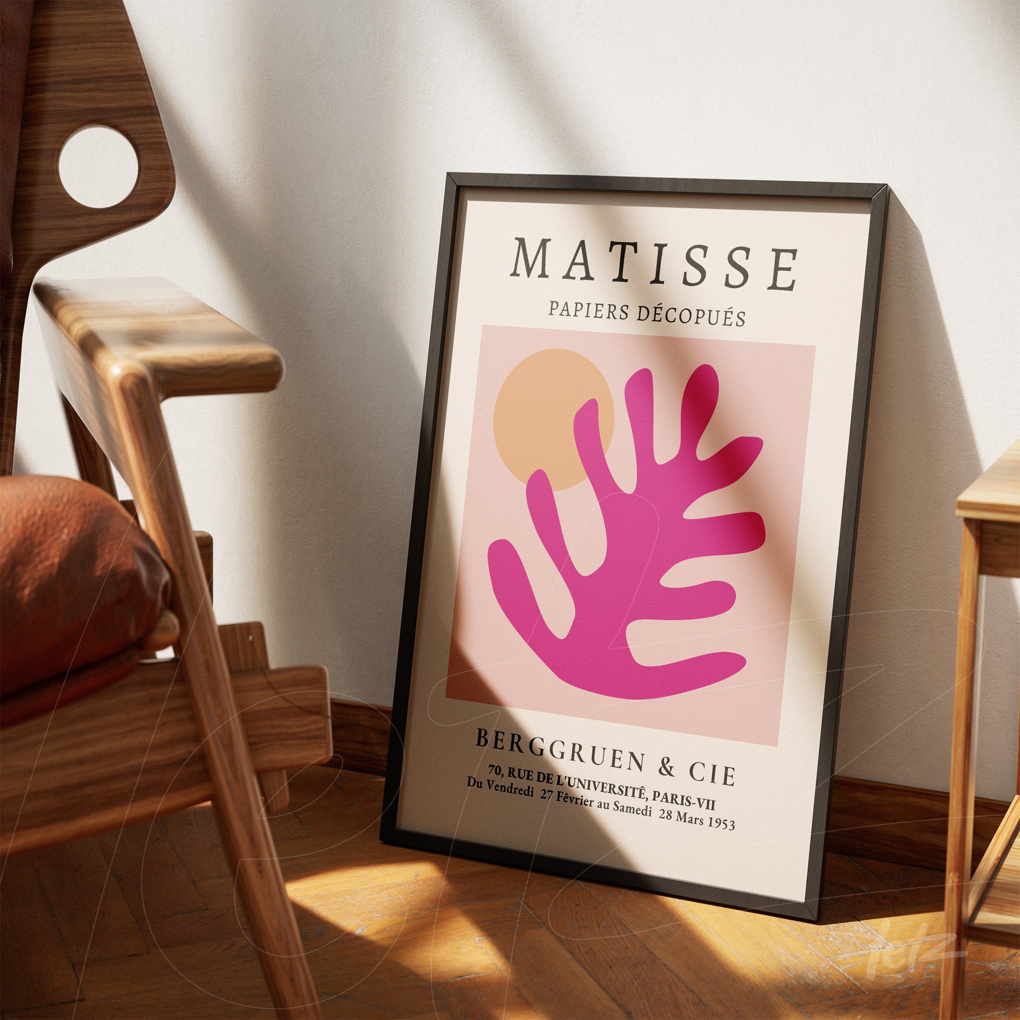 quadro com arte moderna composta por formas abstratas em rosa e laranja, moldura preta fina, apoiado em cadeira de madeira