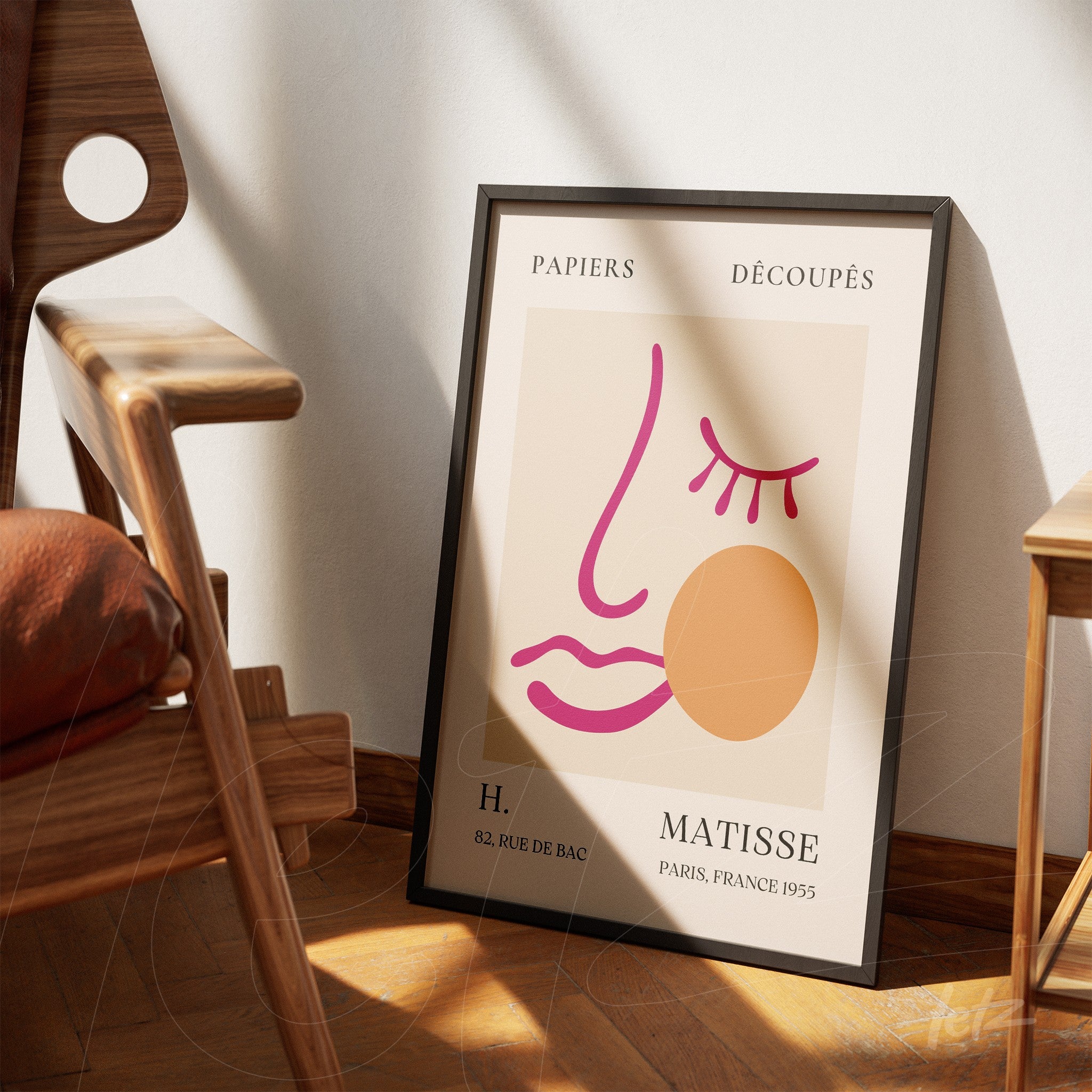 quadro estilizado com arte moderna representando um rosto em linhas simples, exibido ao lado de uma cadeira de madeira sobre piso de madeira