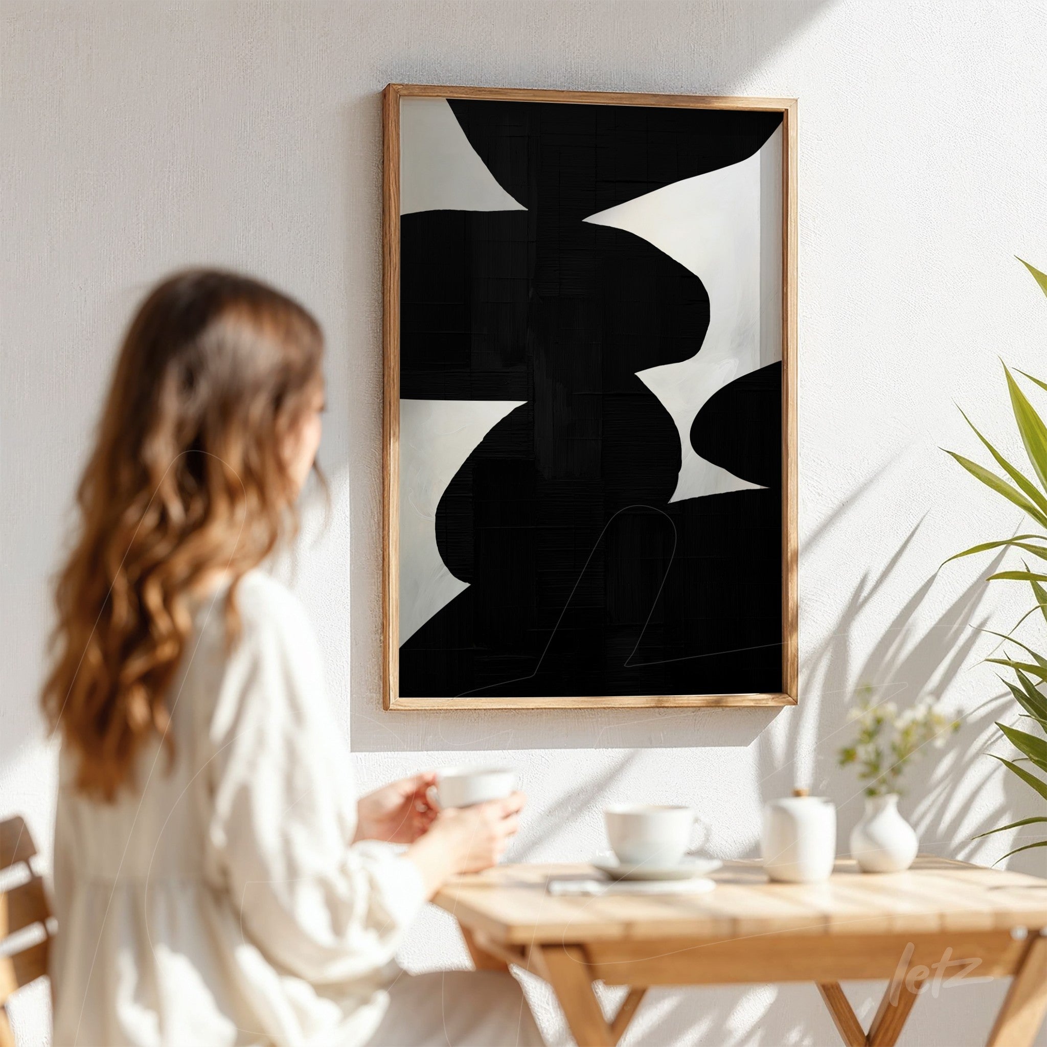 quadro abstrato em tons de preto e branco com moldura de madeira clara exibido em parede clara