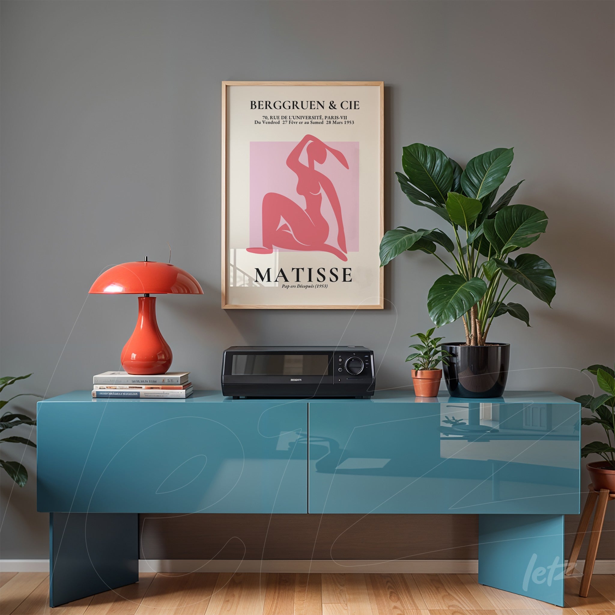 quadro decorativo com arte de Matisse em moldura clara exibido sobre aparador azul, rodeado por plantas e luminária vermelha