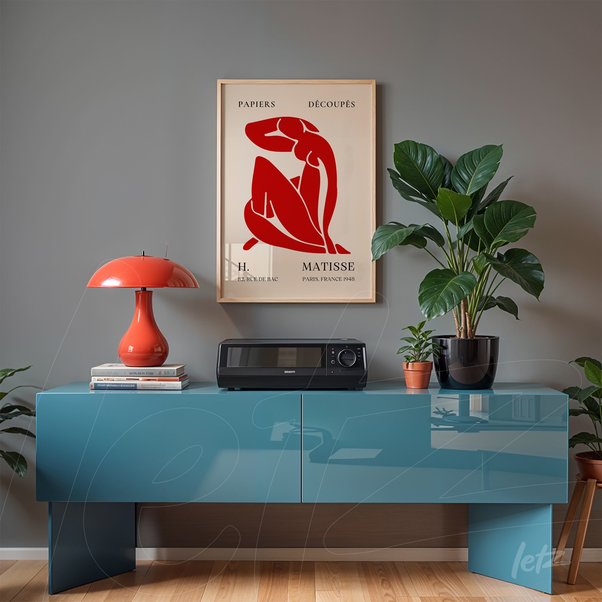 quadro com arte de Matisse emoldurado em estilo vintage sobre mesa azul com plantas ao redor