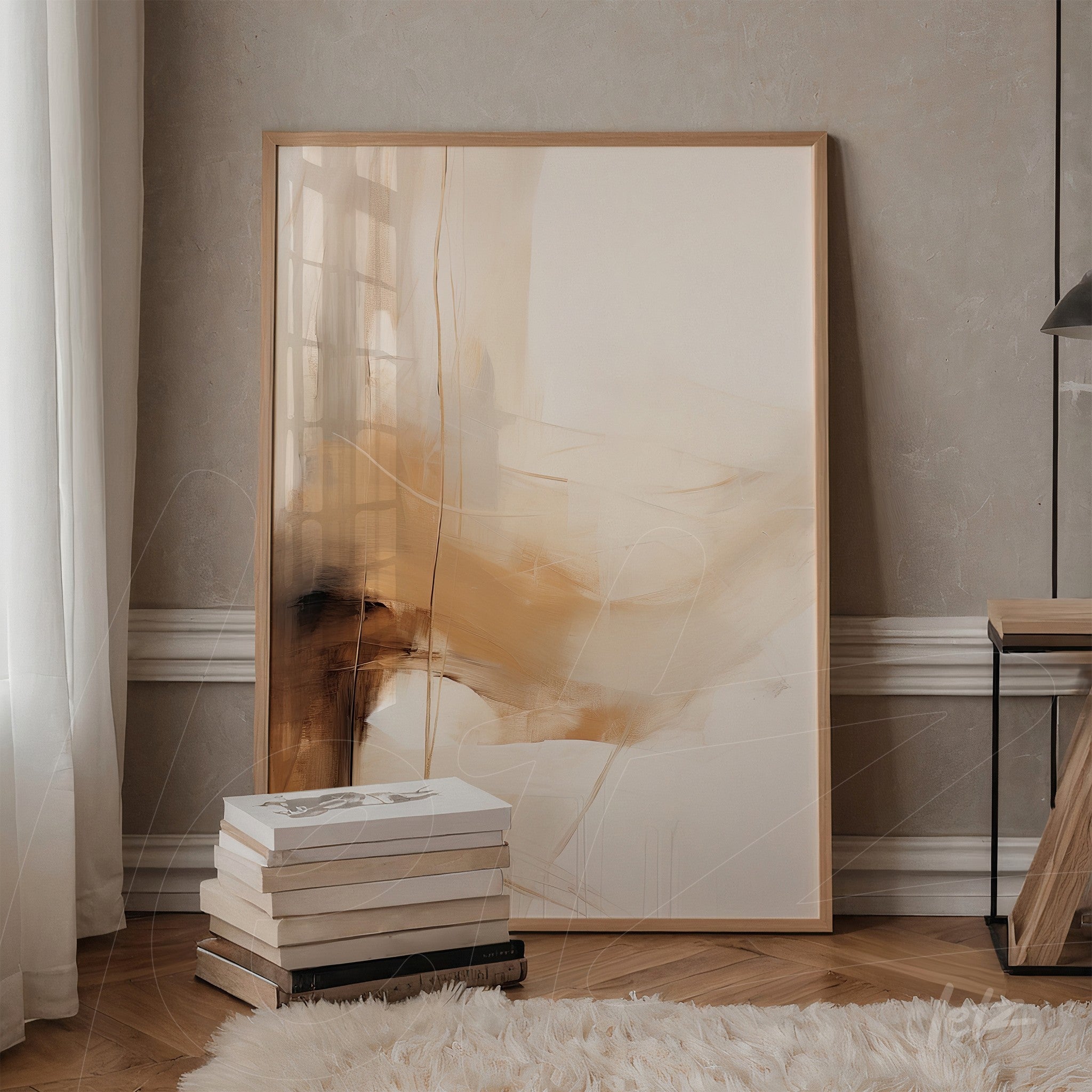quadro abstrato com tons de beige e caramelo em moldura clara, apoiado ao lado de uma mesa de madeira