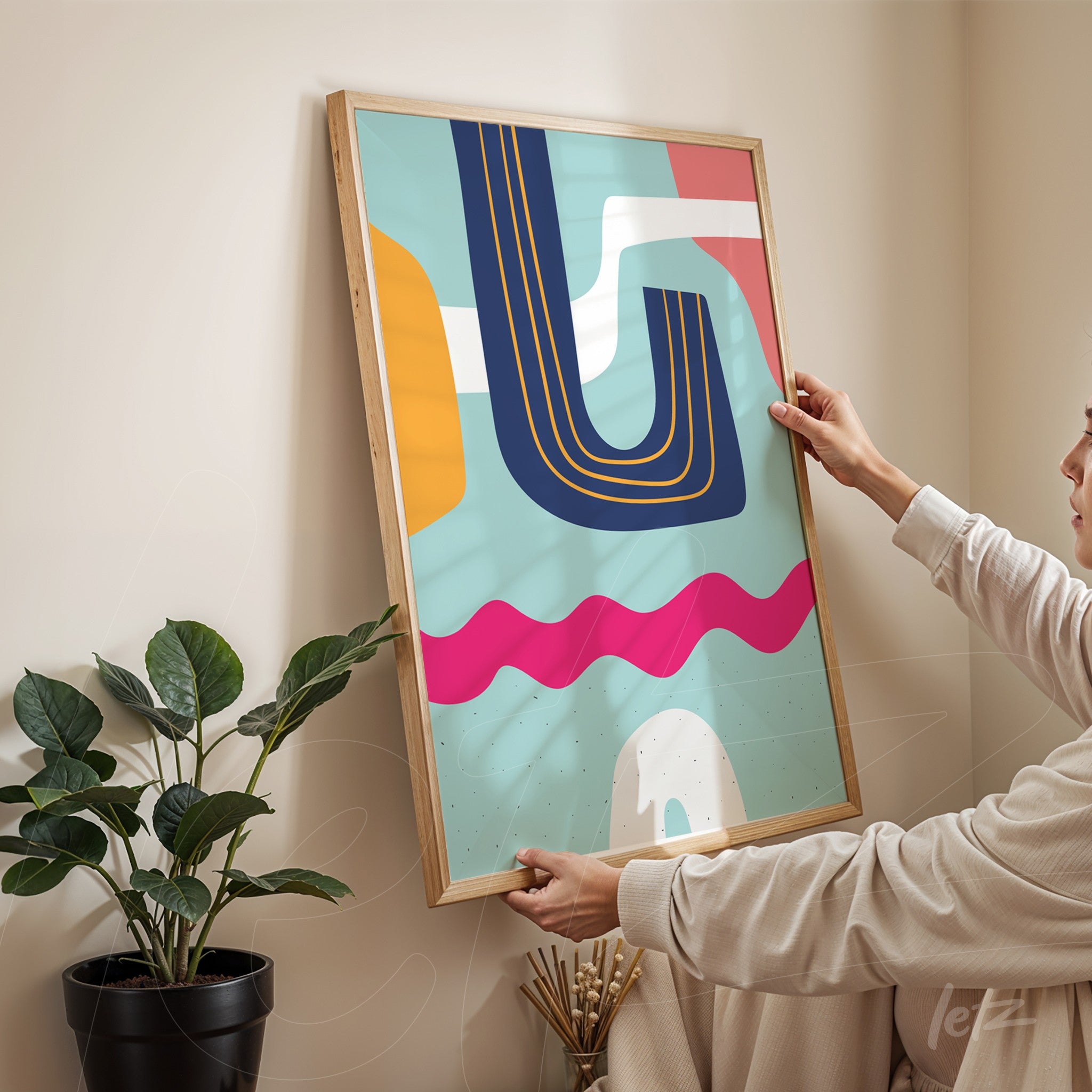 ```json
{
"alt": "quadro boho com formas geométricas em cores modernas, exibido em moldura de madeira clara sendo segurado por uma pessoa ao lado de uma planta",
"alt_en": "boho wall art with geometric shapes in modern colors, displayed in a light wooden frame held by a person next to a plant"
}
```