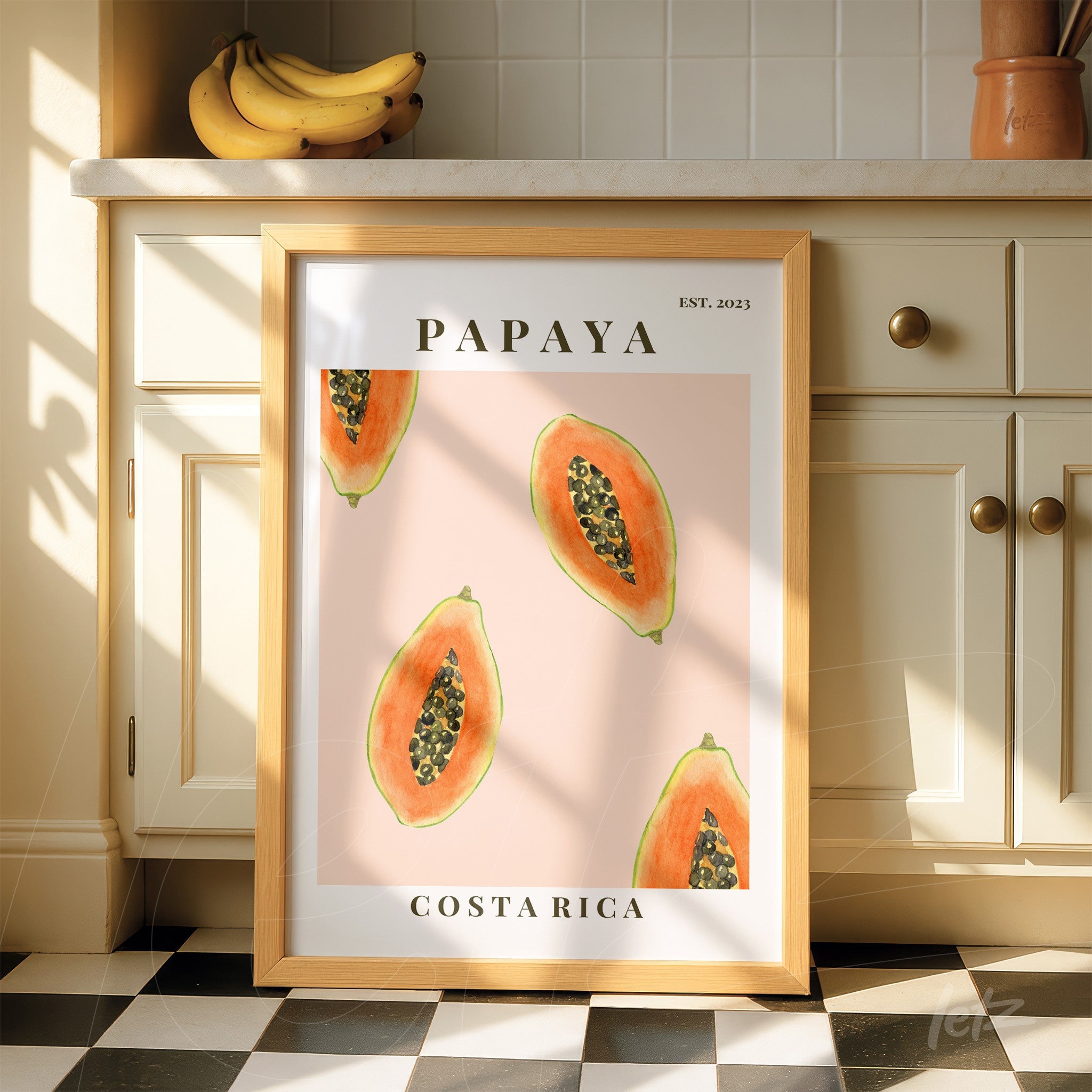 quadro com arte de papaias em fundo rosa, moldura de madeira clara e texto 'PAPAYA' e 'COSTA RICA'