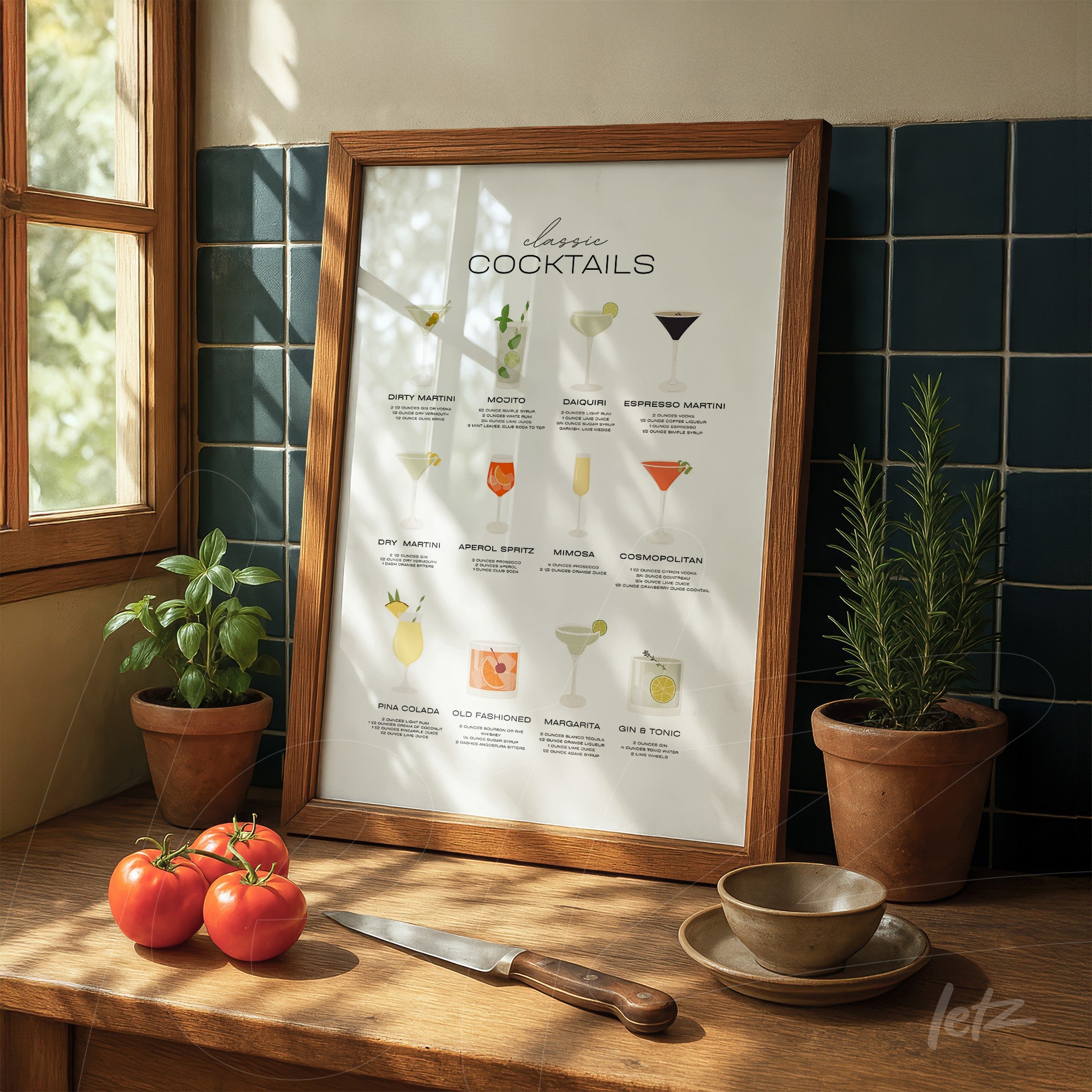 quadro com ilustrações de coquetéis clássicos em moldura de madeira, exposto sobre mesa de madeira com tomate ao lado