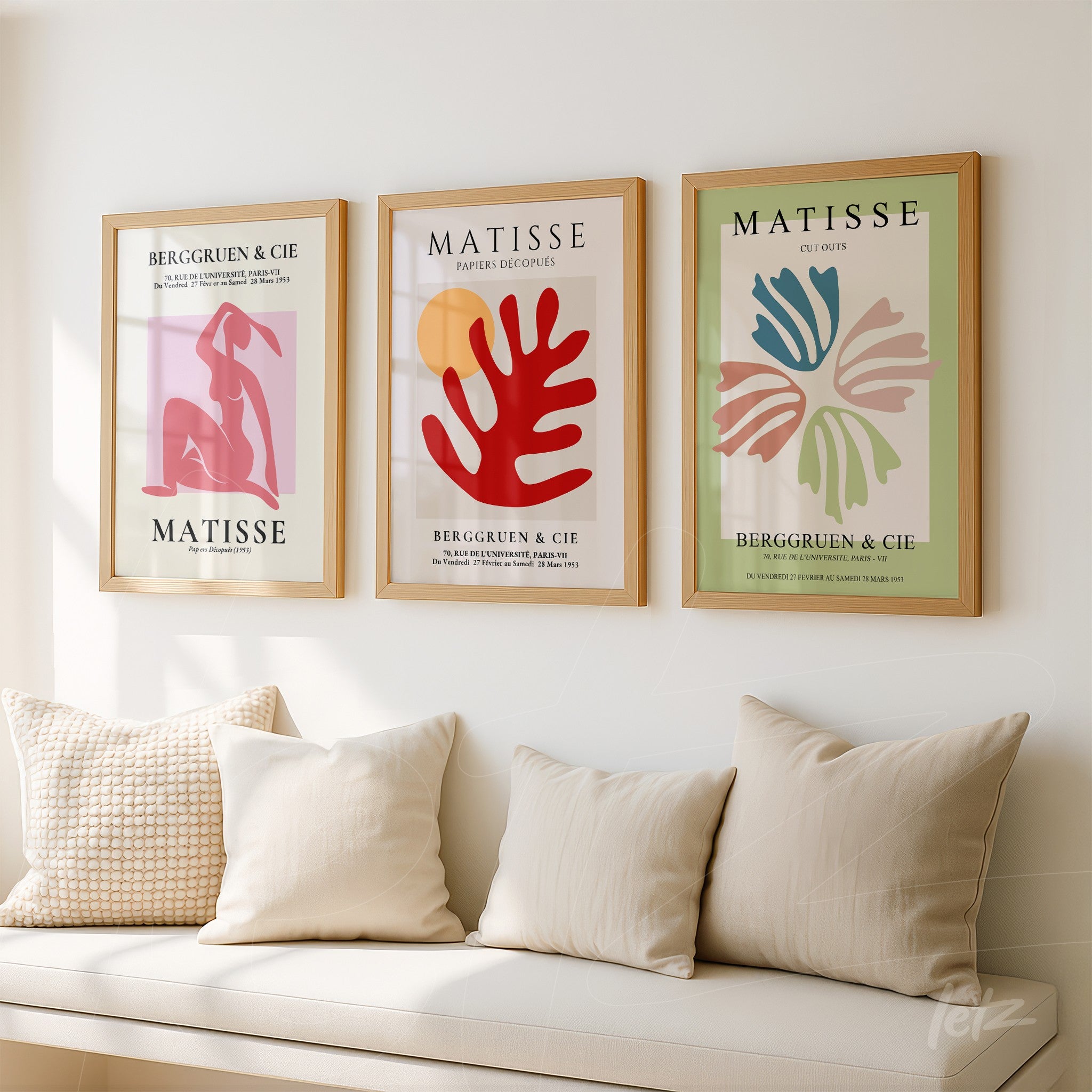 composição com três quadros de arte moderna em moldura de madeira clara, apresentando trabalhos de Matisse sobre parede clara, com almofadas em sofá