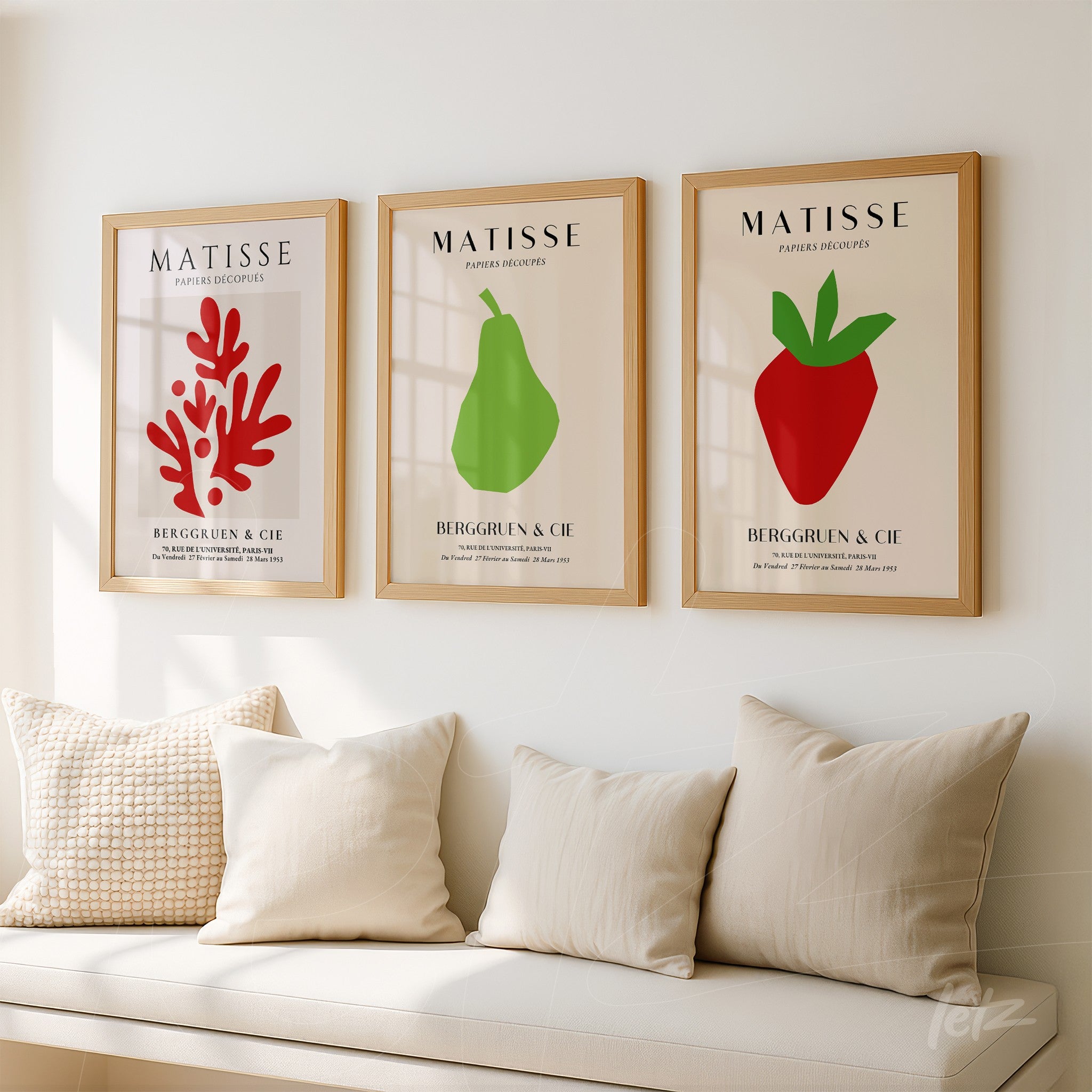 composição de três quadros decorativos com ilustrações em estilo moderno de um coral vermelho, uma pera verde e um morango vermelho, todos em molduras de madeira clara apresentando fundo neutro