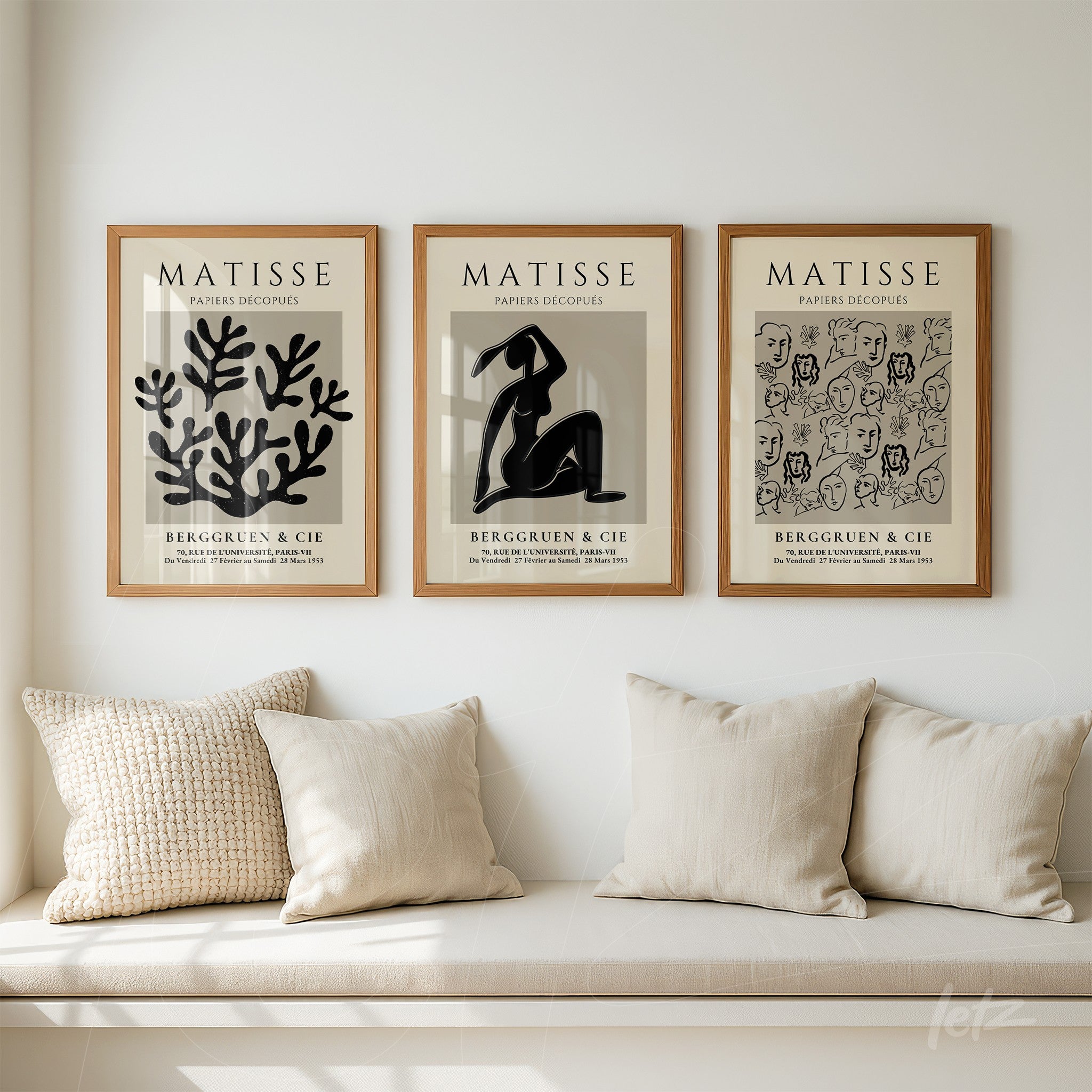 série de quadros com arte de Matisse em moldura de madeira clara, exibidos sobre um sofá com almofadas creme