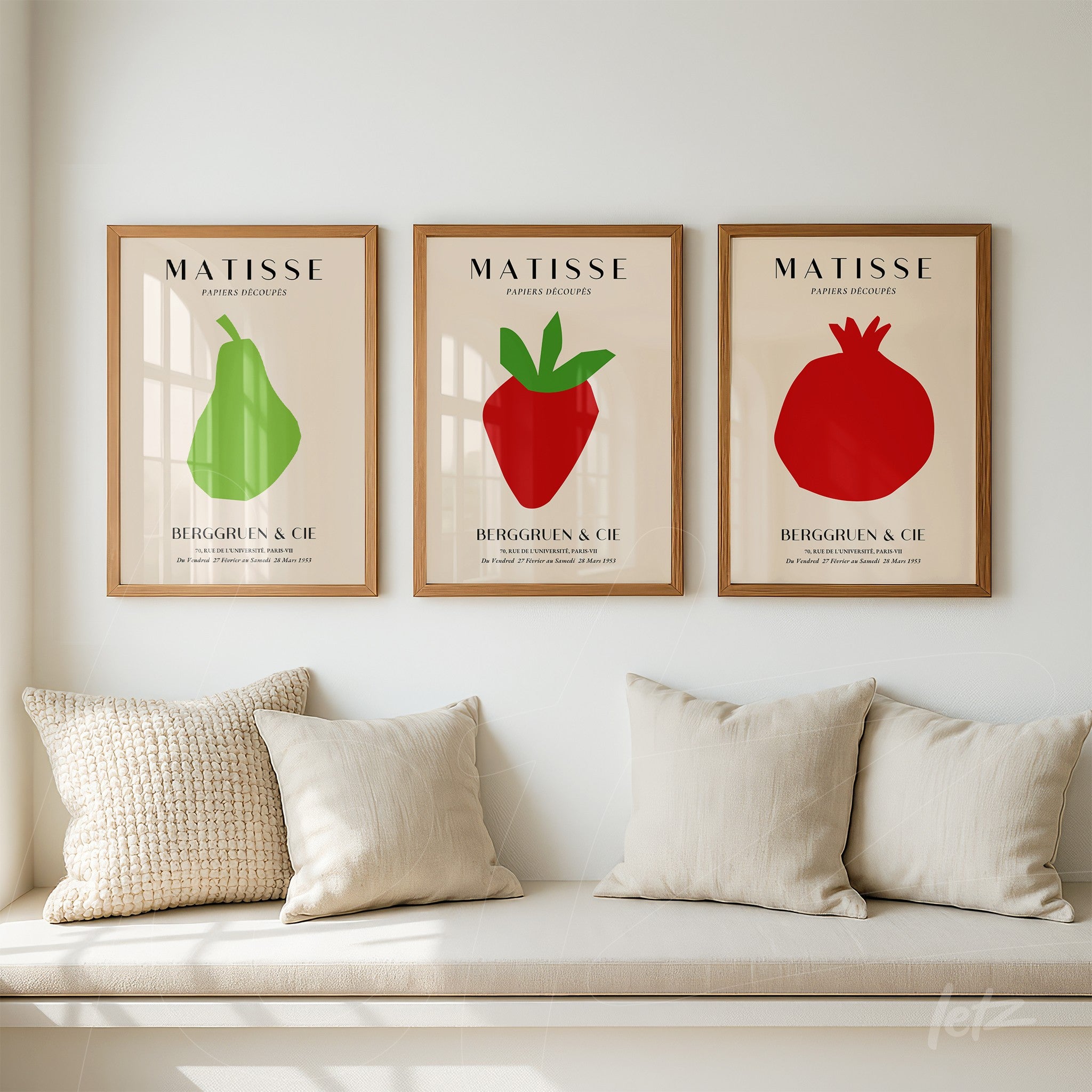 composição de três quadros decorativos com ilustrações minimalistas de frutas coloridas em molduras de madeira clara sobre uma parede clara