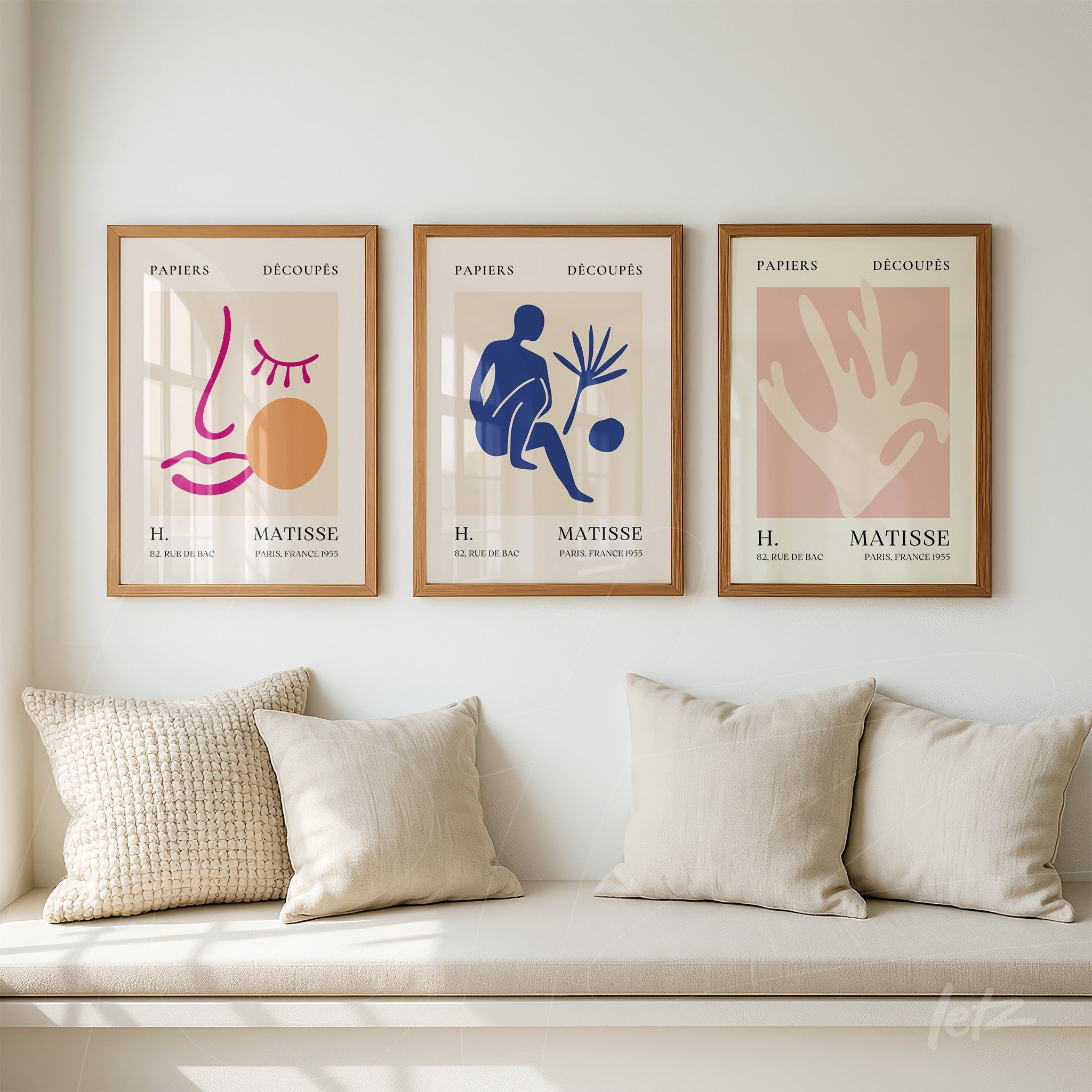 composição de quadros decorativos em molduras de madeira clara com artes abstratas em cores vibrantes sobre fundo claro