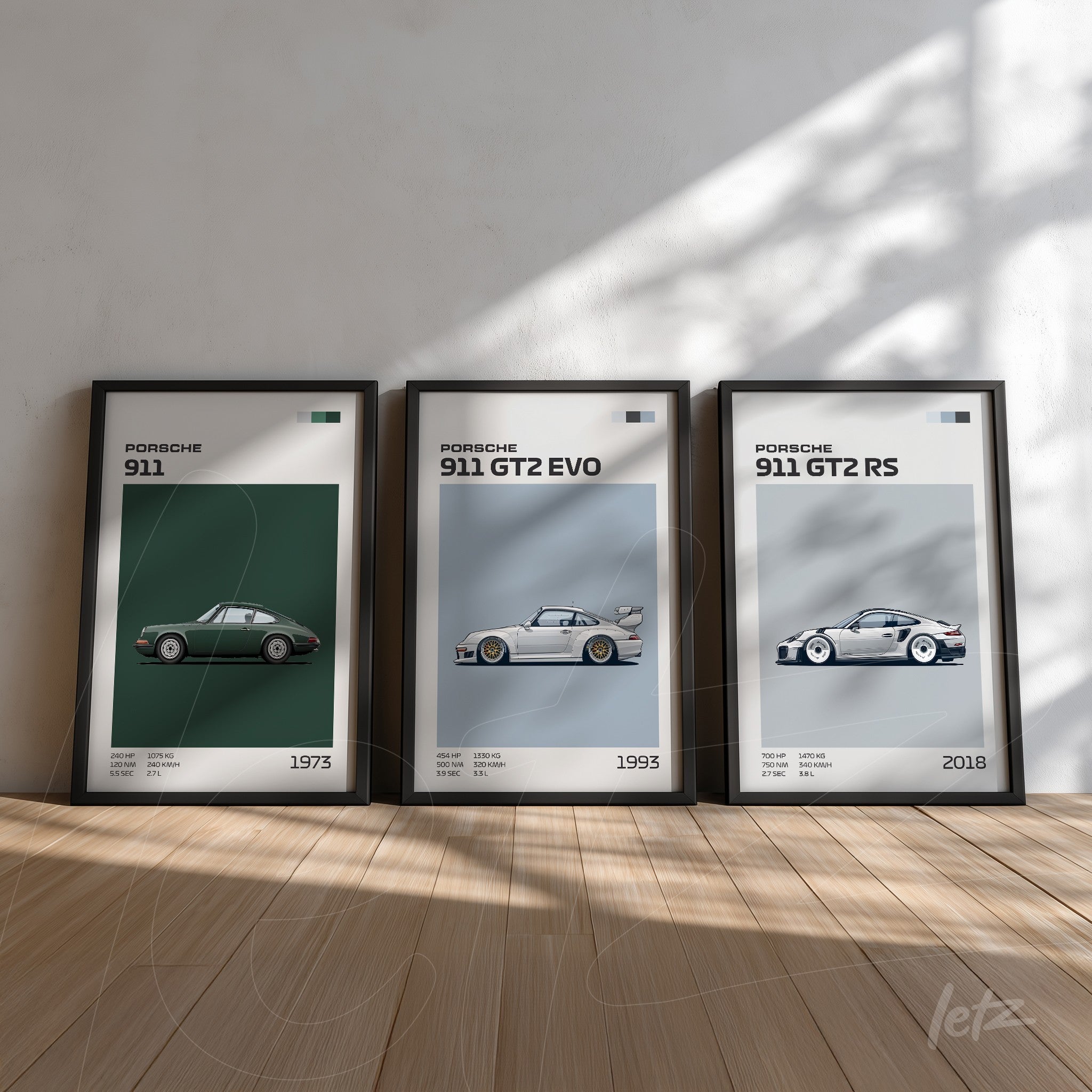 composição com três quadros de carros Porsche, sendo um modelo 911 de 1973, um 911 GT2 EVO de 1993 e um 911 GT2 RS de 2018, todos em moldura preta com fundo claro e iluminação natural