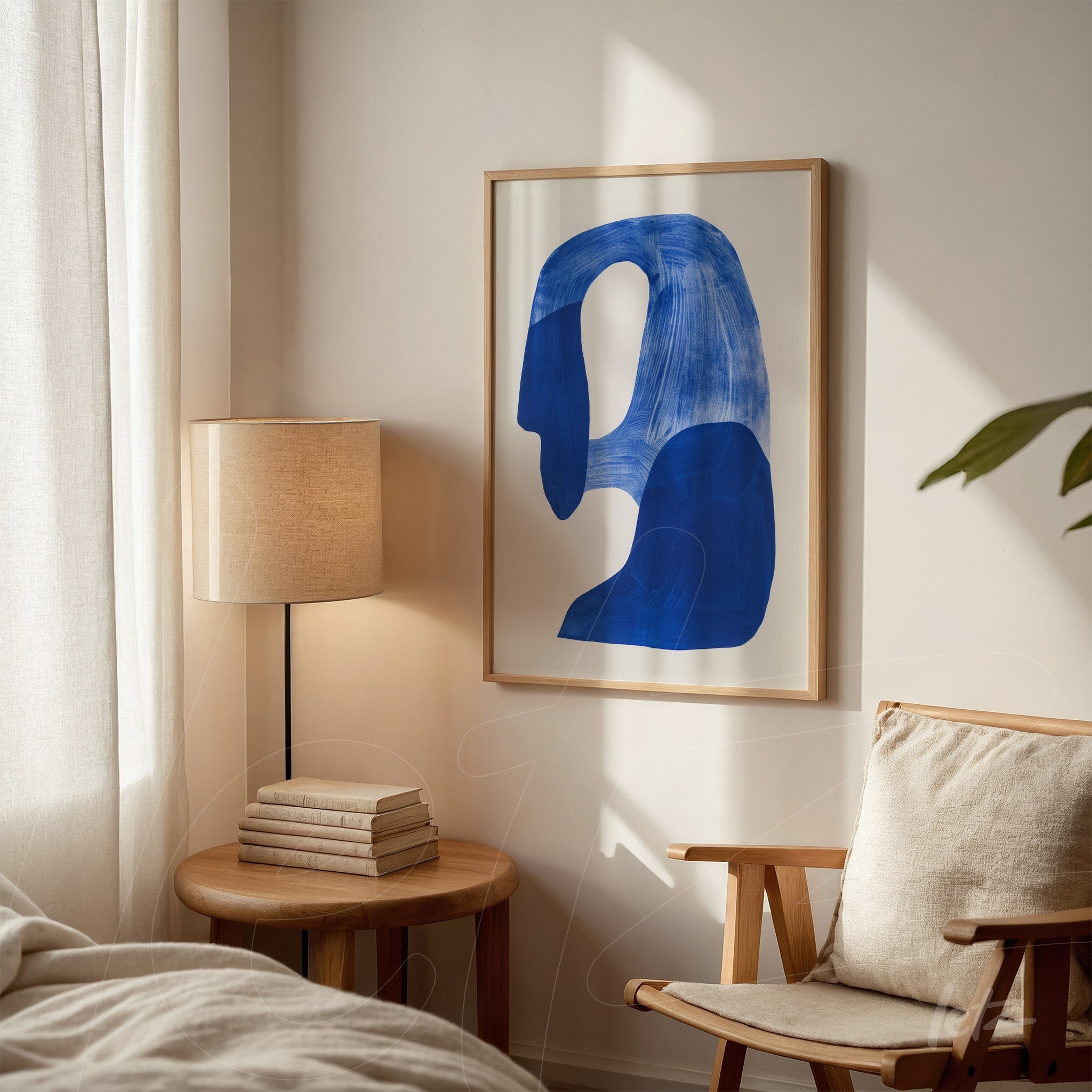 quadro com arte abstrata em azul em moldura clara, com fundo neutro e elementos de decoração como abajur e livros ao lado