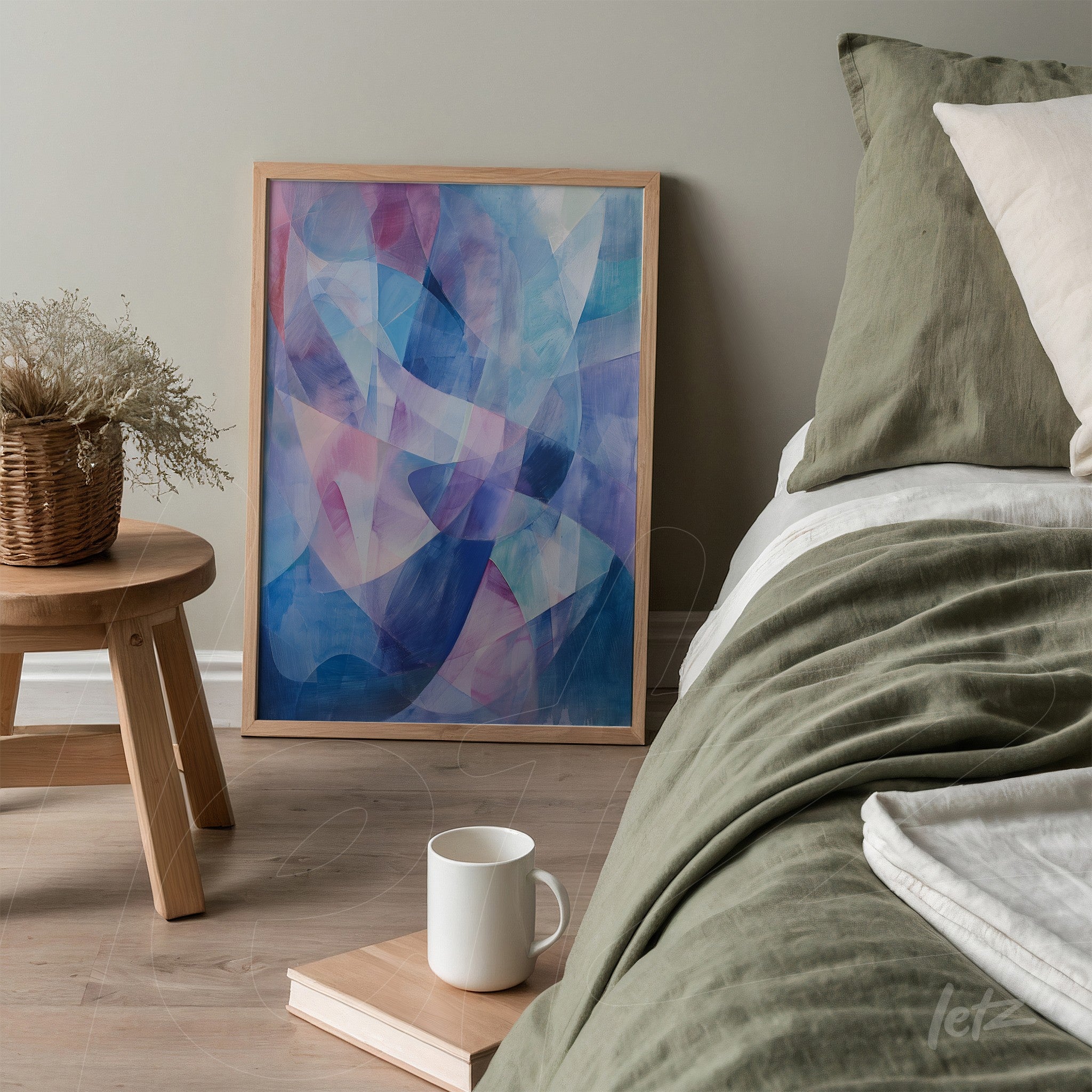 quadro abstrato em moldura clara com tonalidades azuis e rosas apoiado ao lado da cama em quarto moderno