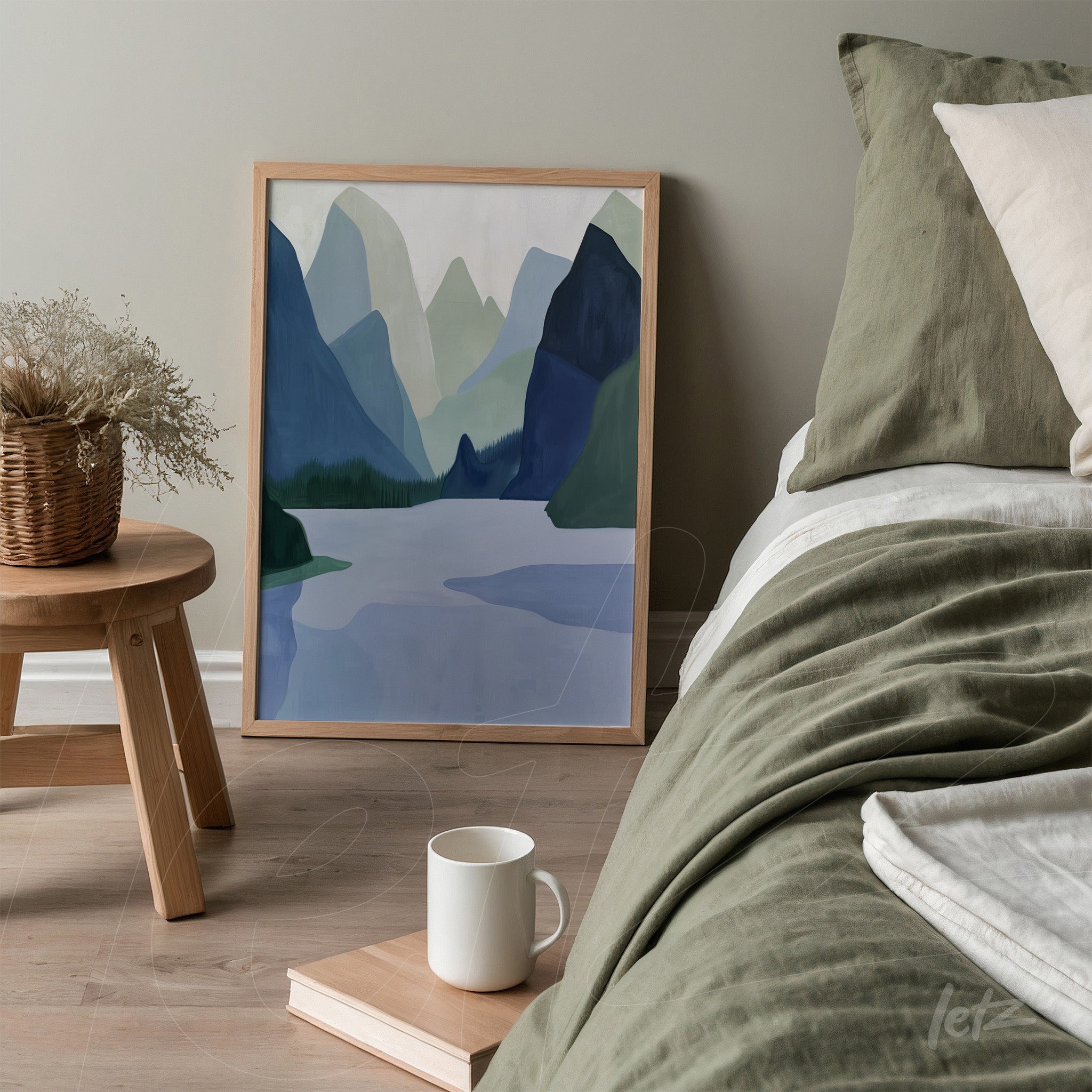 quadro em moldura clara com paisagem montanhosa em tons de azul e verde, apoiado ao lado da cama em um ambiente com decoração neutra