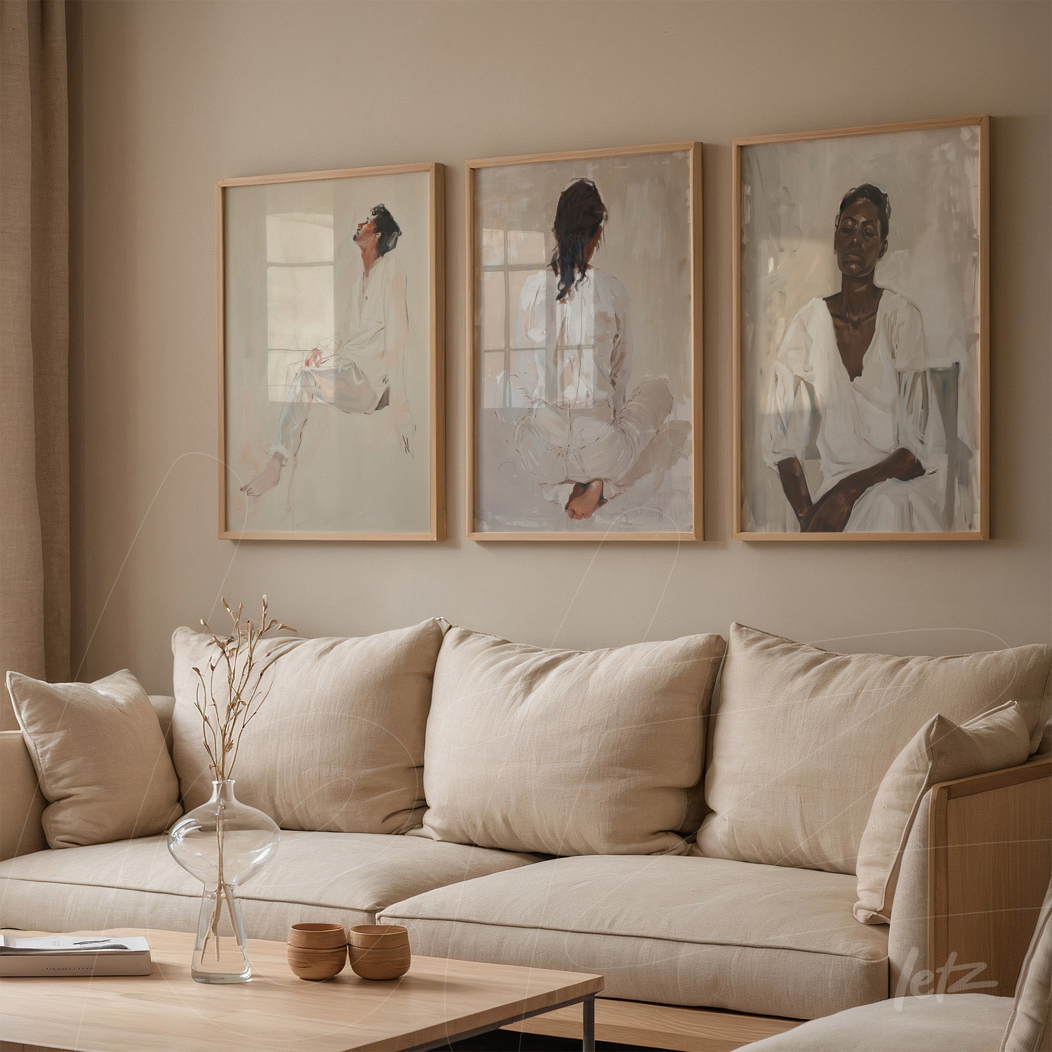 composição de três quadros decorativos com retratos femininos em moldura clara sobre parede neutra, exibidos acima de sofá em tonalidades suaves