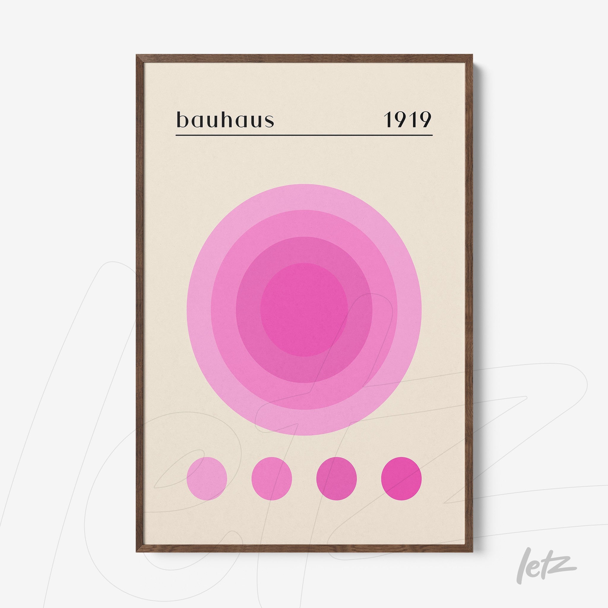 quadro com círculos concêntricos em tons de rosa com texto bauhaus 1919 em moldura de madeira