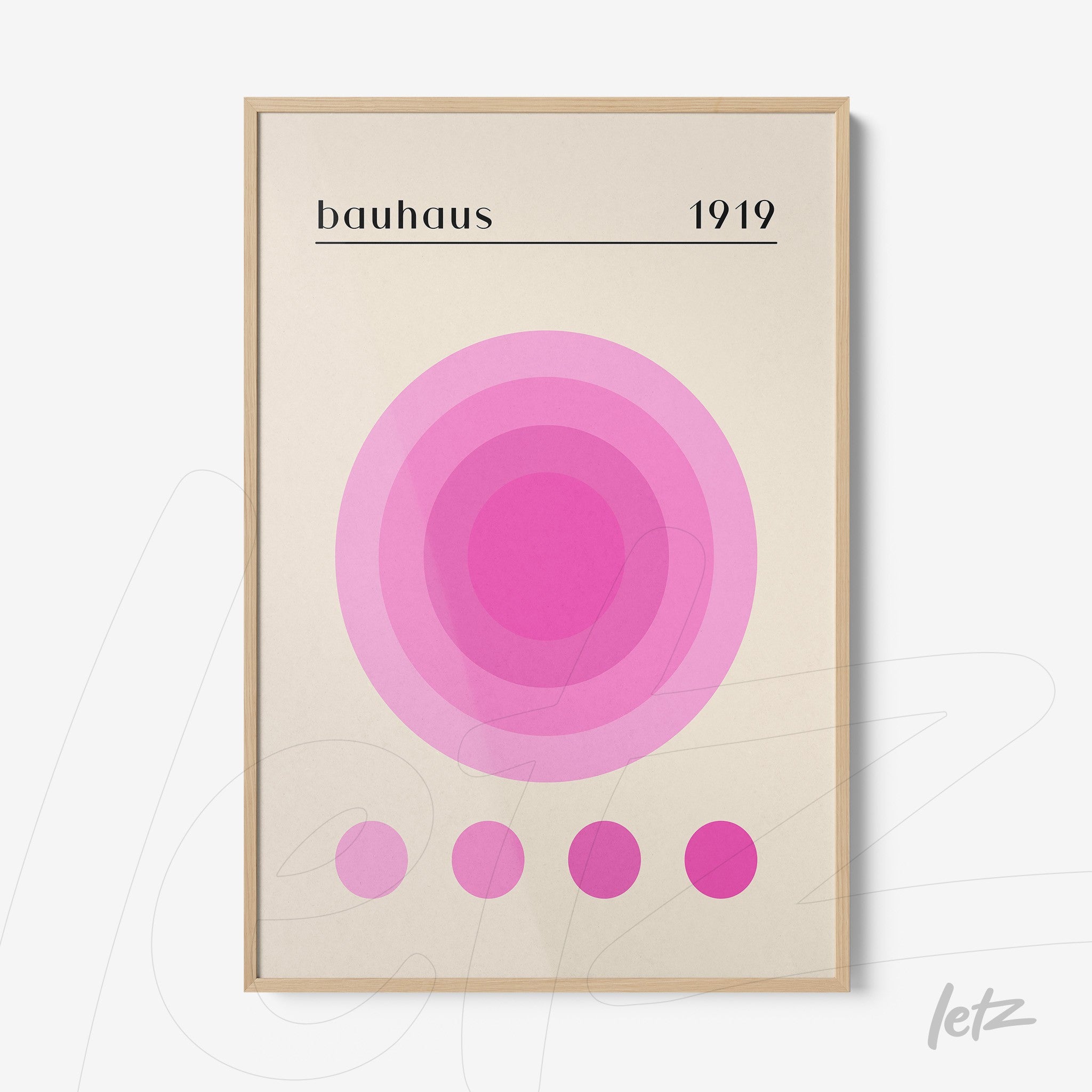 impressão com arte geométrica em tons de rosa e texto 'bauhaus 1919' com moldura de madeira clara