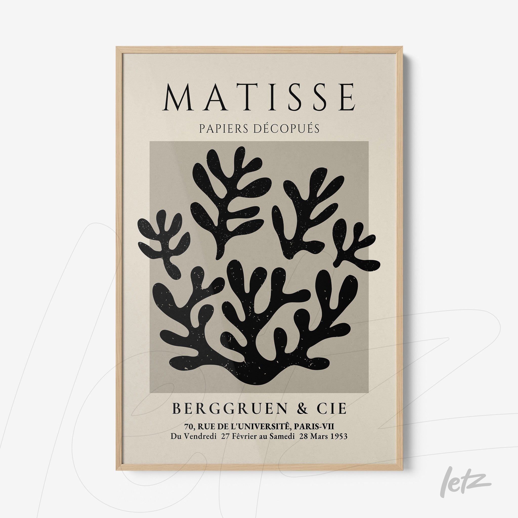 quadro com arte abstrata de recortes em preto, com moldura de madeira clara e fundo creme