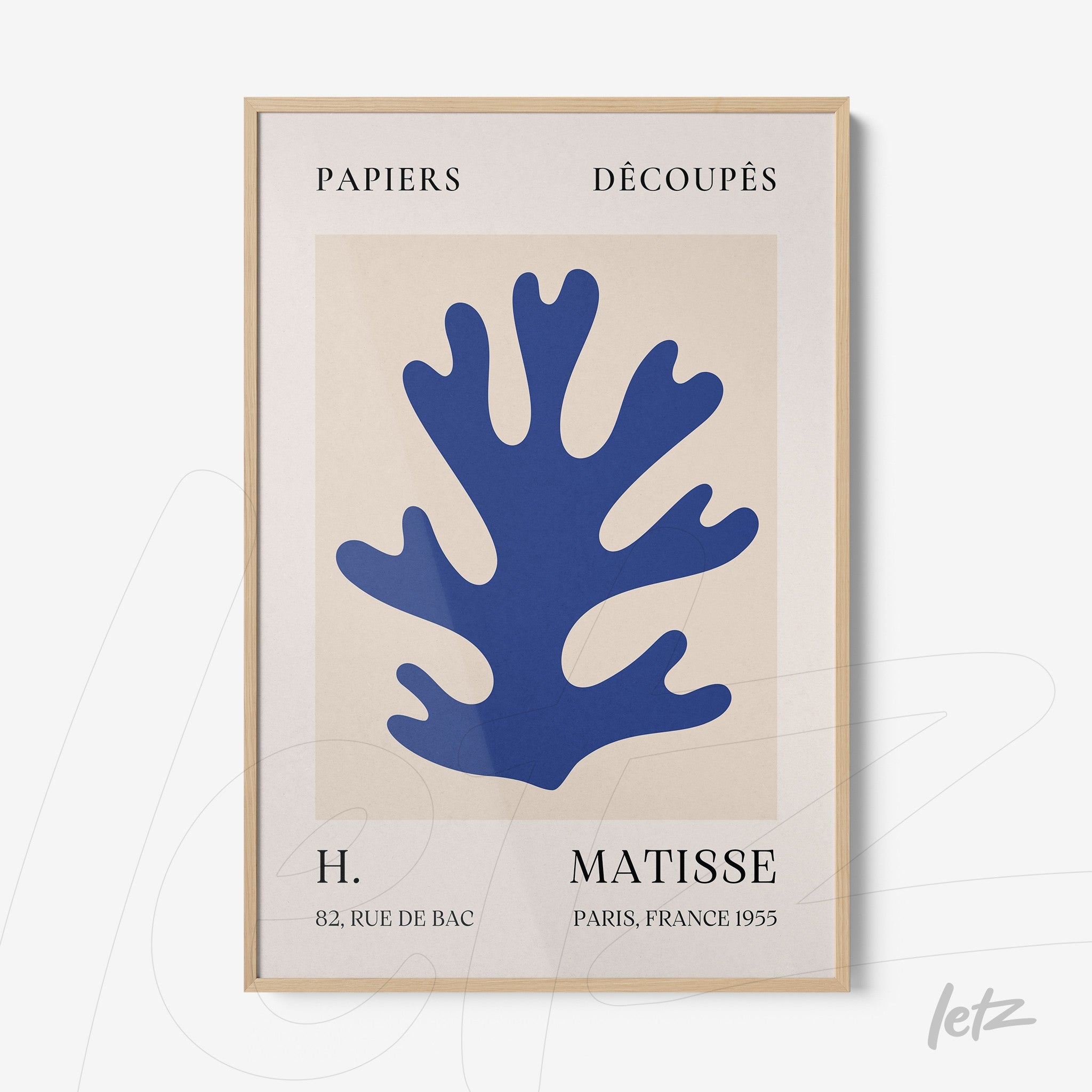 quadro com arte de recortes de papel na cor azul em fundo creme, moldura de madeira clara