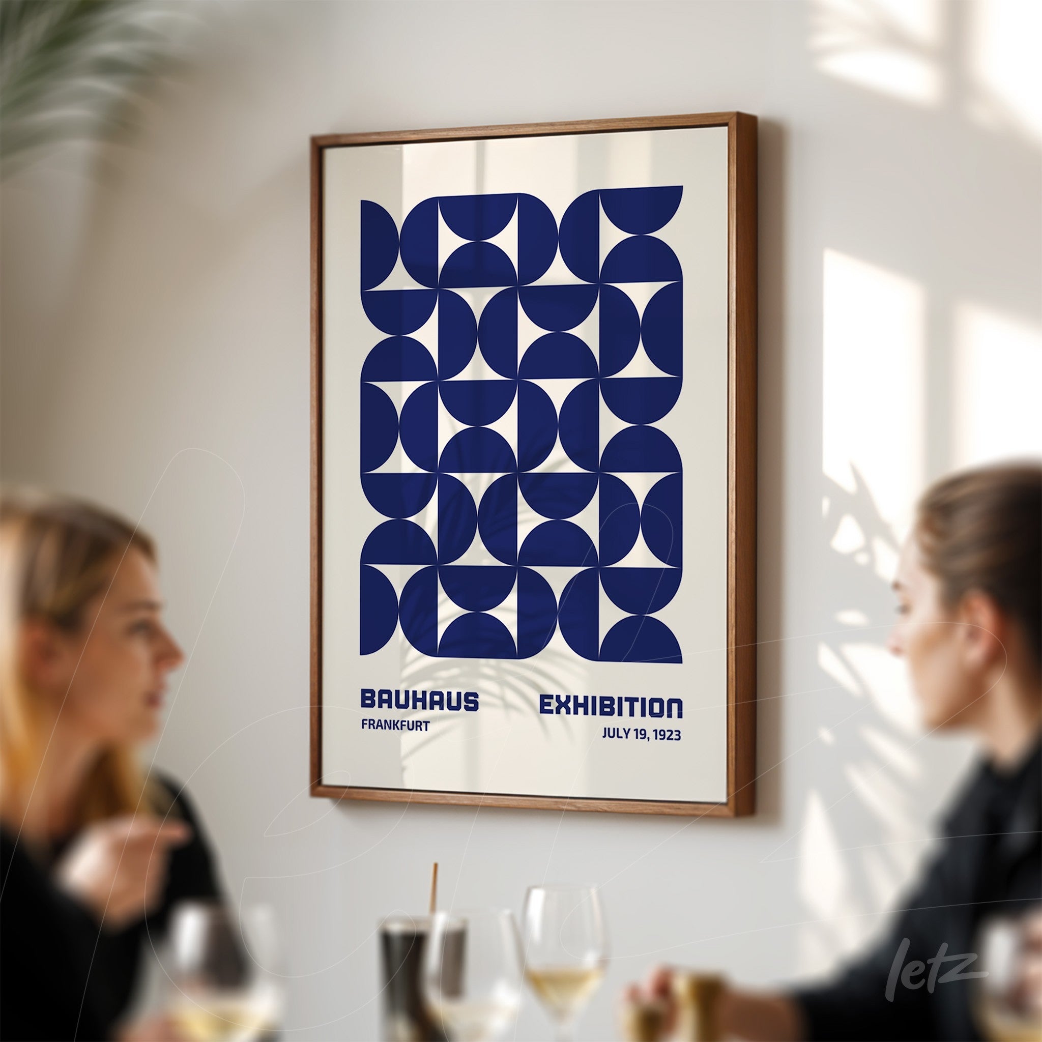 pôster da exposição Bauhaus de Frankfurt em 1923 com design geométrico simétrico em moldura de madeira, exibido em parede clara