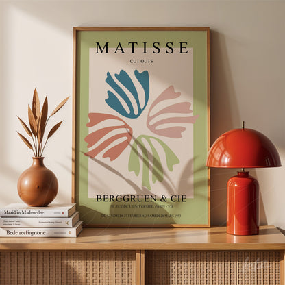 quadro decorativo com obra de Matisse em moldura de madeira clara, exibindo formas orgânicas coloridas em fundo verde suave sobre aparador de madeira