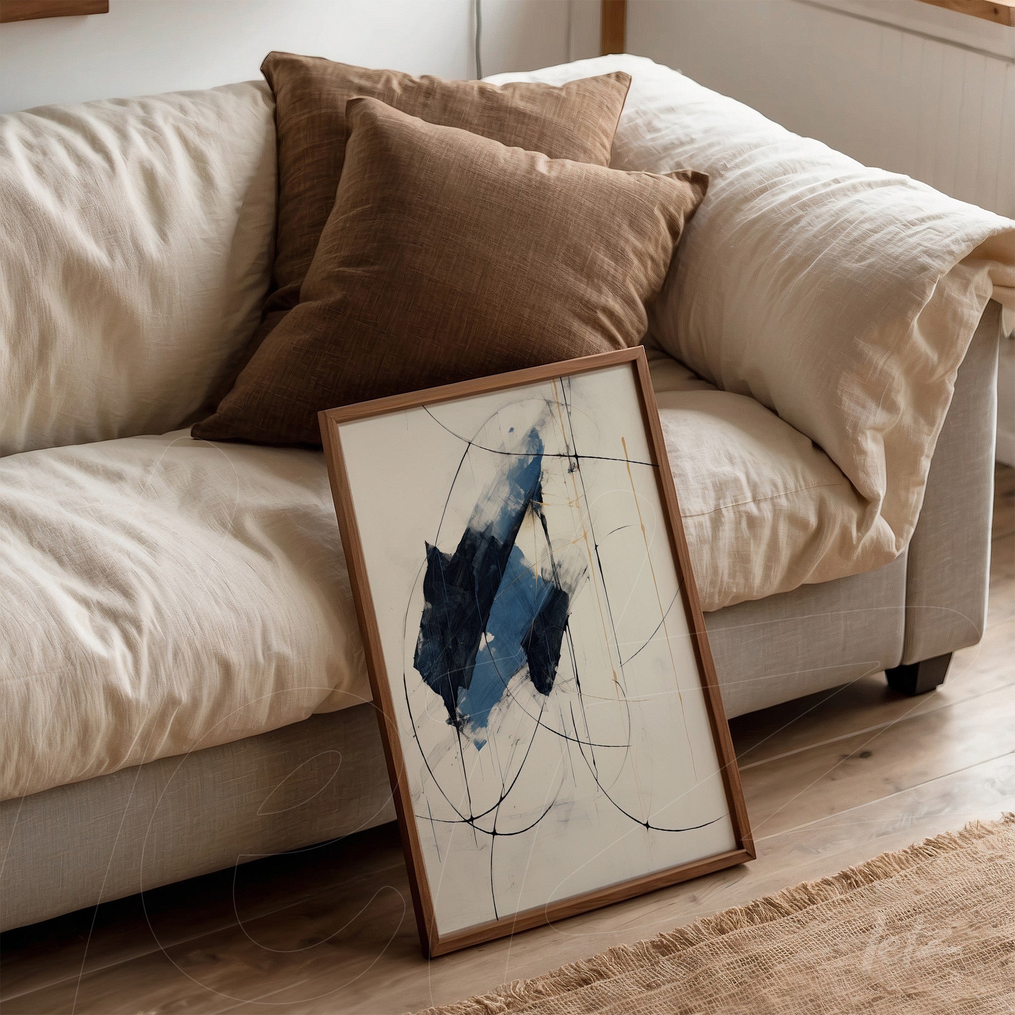 quadro com arte abstrata em azul e branco apoiado em sofá com almofadas marrons
