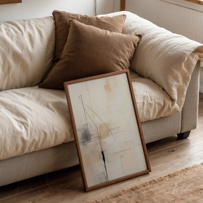 quadro abstrato com linhas em tons neutros apoiado em sofá claro com almofadas marrons