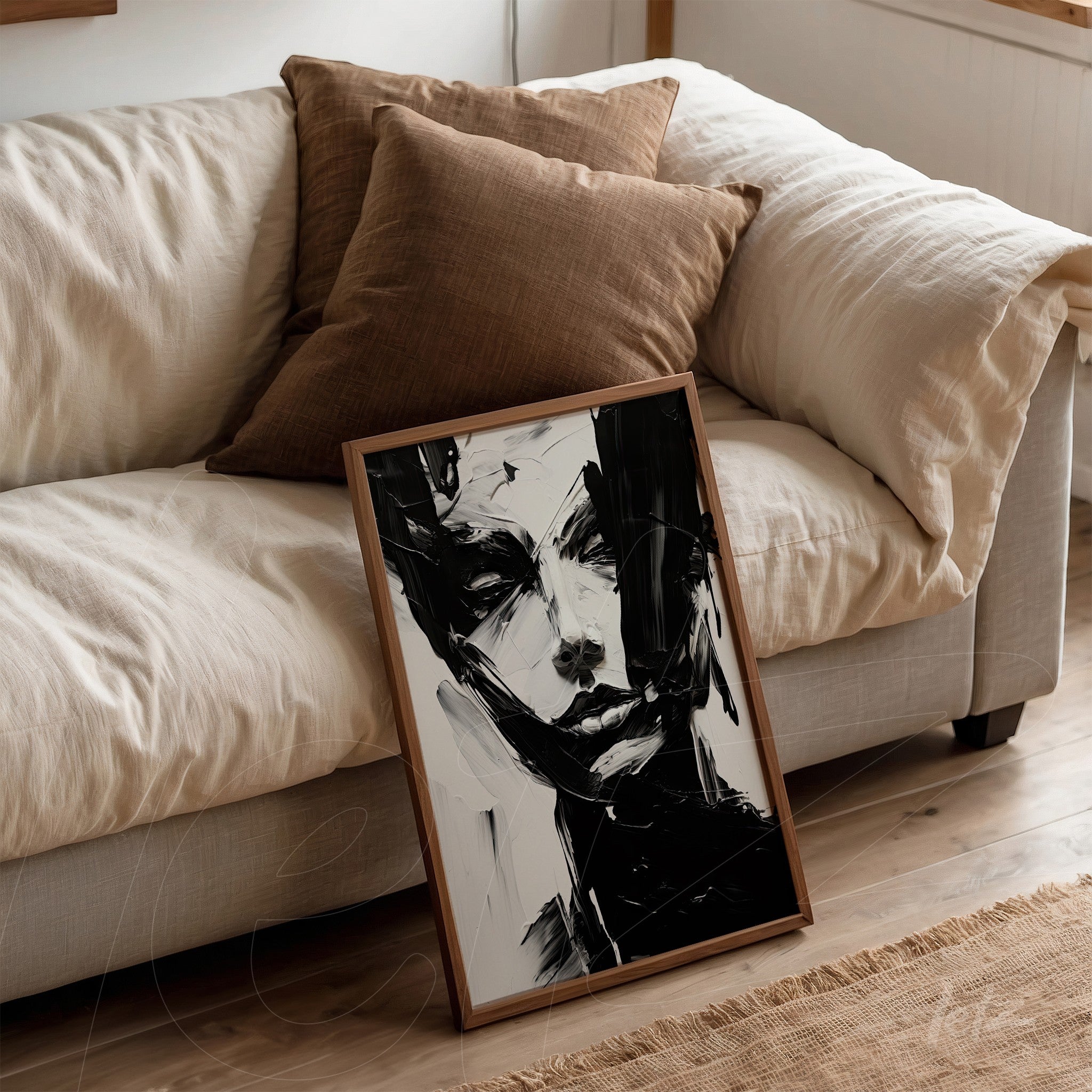 quadro com arte abstrata de rosto humano em moldura de madeira clara apoiado em sofá