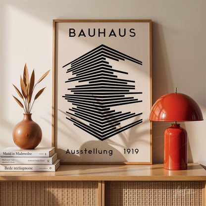 poster com arte geométrica minimalista e texto 'bauhaus ausstellung 1919' em moldura de madeira clara apoiado em móvel de madeira ao lado de lâmpada vermelha