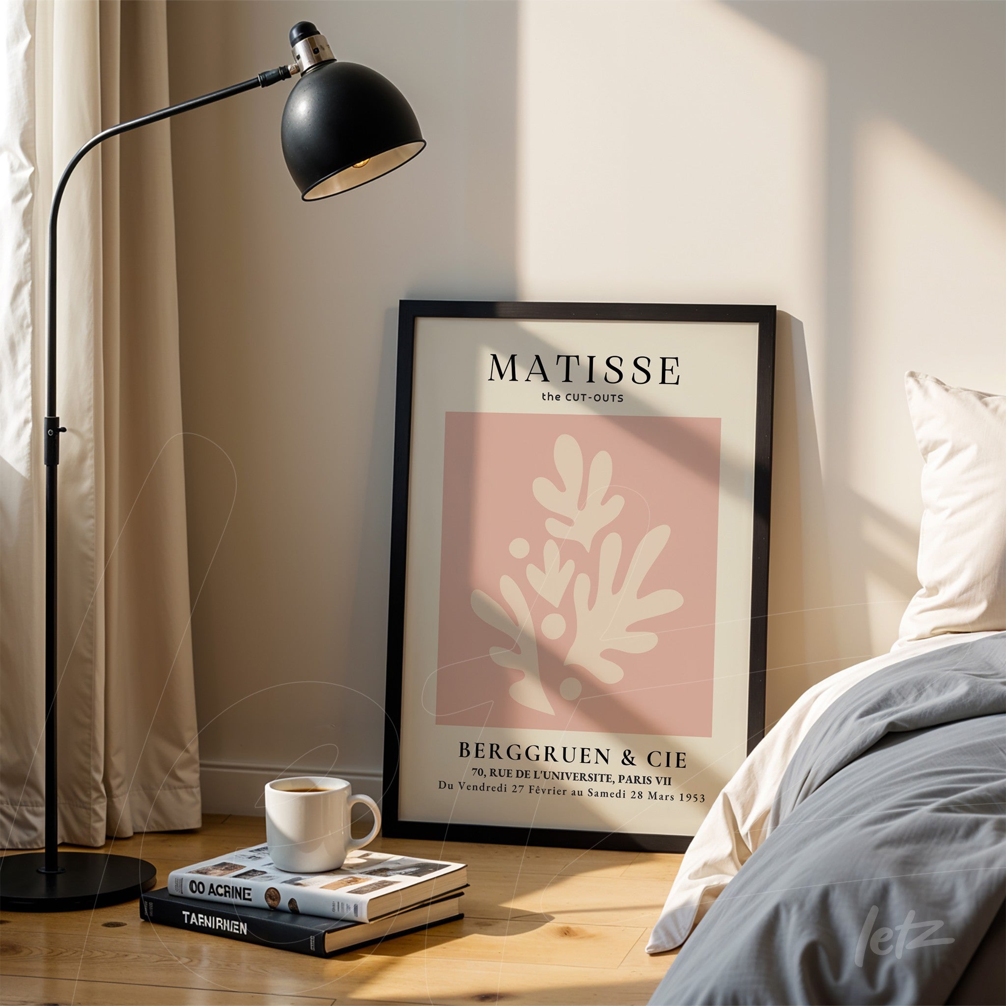 quadro com arte de Matisse em moldura preta com fundo rosa e elementos em destaque sobre mesa de madeira