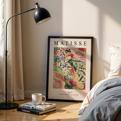 quadro com arte inspirada em Matisse intitulado 'La Japonaise' em moldura preta apoiado ao lado de uma luminária moderna