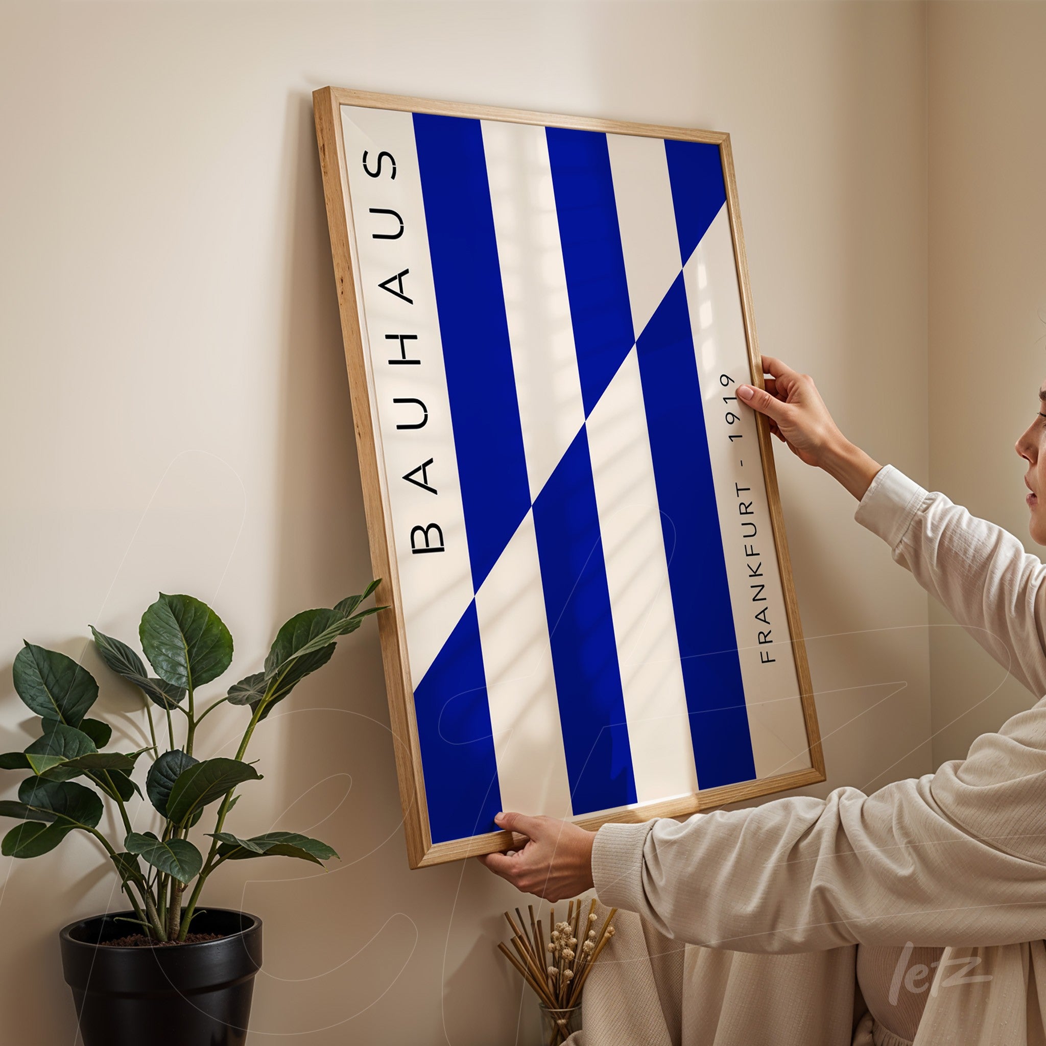 quadro emoldurado com design geométrico azul e branco inspirado em bauhaus, apoiado em parede de canto