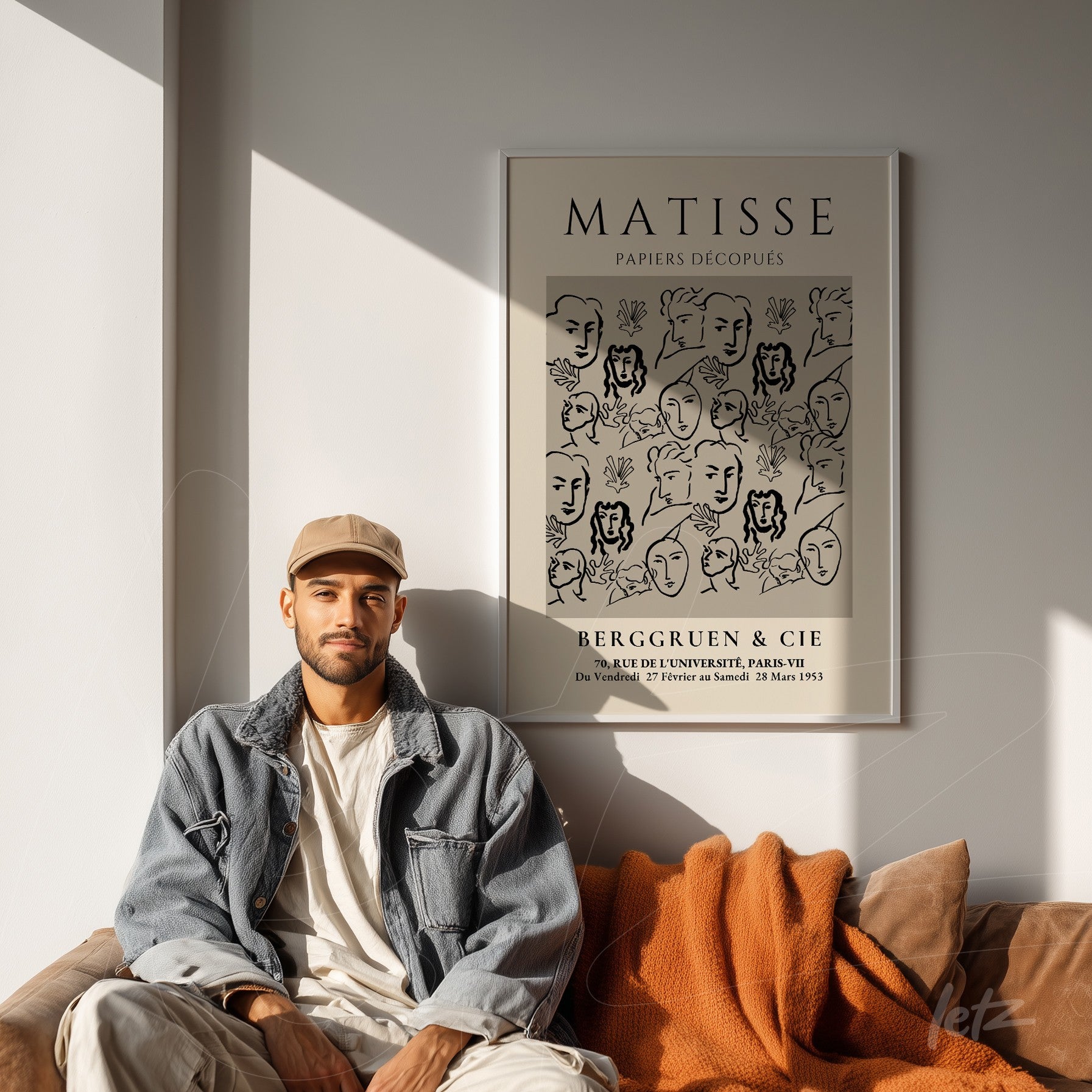 quadro emoldurado com arte moderna de rostos em preto e branco de Matisse, exibido sobre parede clara ao lado de um homem vestido de forma casual