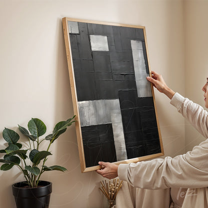 quadro abstracto com formas geométricas em tons de preto e prata em moldura de madeira clara