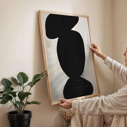 quadro moderno com formas abstratas em preto sobre fundo claro em moldura de madeira clara