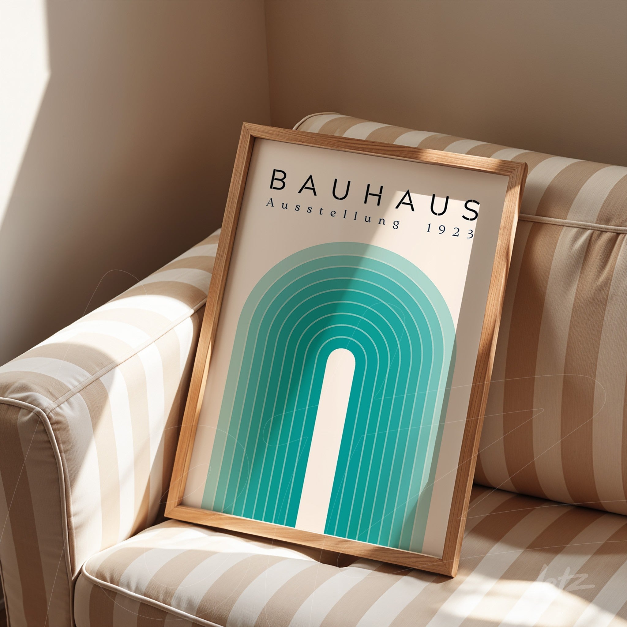 quadro com arte geométrica estilo Bauhaus em moldura de madeira clara apoiado em sofá listrado