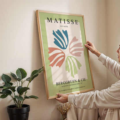 quadro decorativo com arte abstrata em estilo moderno, moldura de madeira clara, apresentando formas coloridas em fundo verde