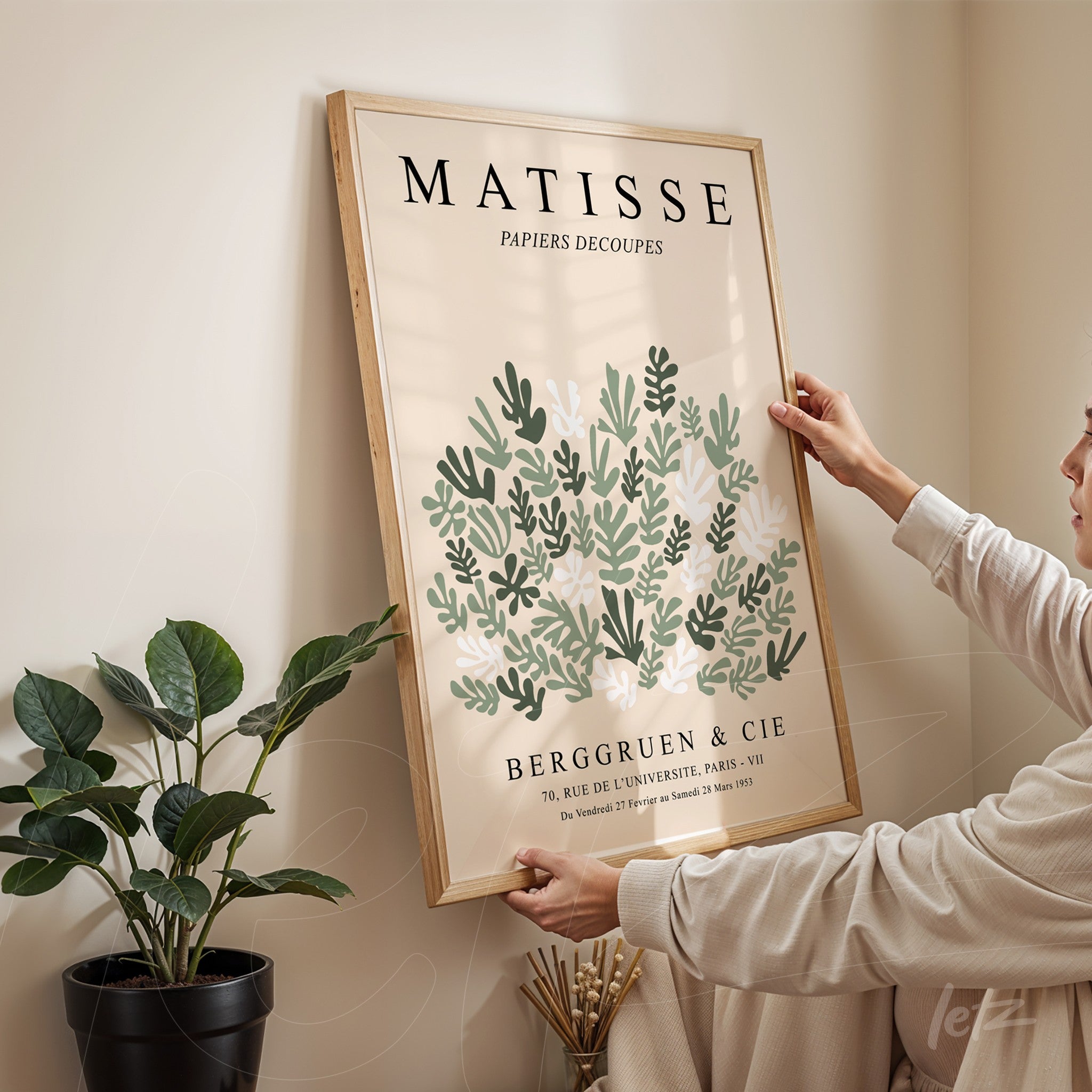 quadro decorativo com design de folhas em estilo vintage, moldura de madeira clara e texto artístico em destaque