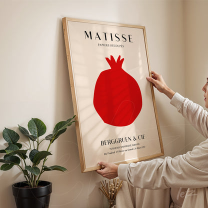 quadro com arte de Matisse ilustrando uma romã vermelha em moldura de madeira clara