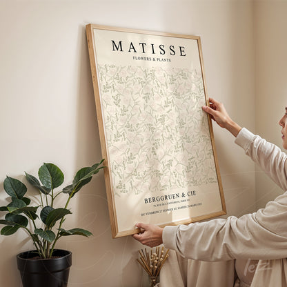 quadro de arte decorativa com design floral de Matisse, exposto em moldura de madeira clara sobre parede neutra